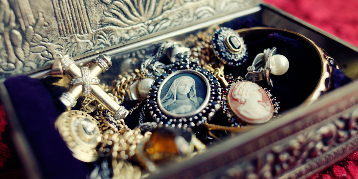 Accessoires luxe pour bijoux et montres dans une boîte en métal ornée, avec des bijoux raffinés.