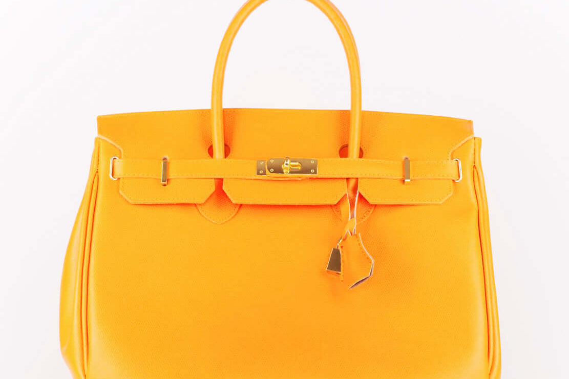 Luxury rare collector items: vibrant orange designer handbag showcasing elegance and timeless style.