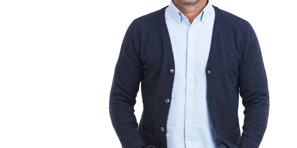 Homme souriant portant un cardigan bleu, dans le cadre de la masculine sportswear collection.