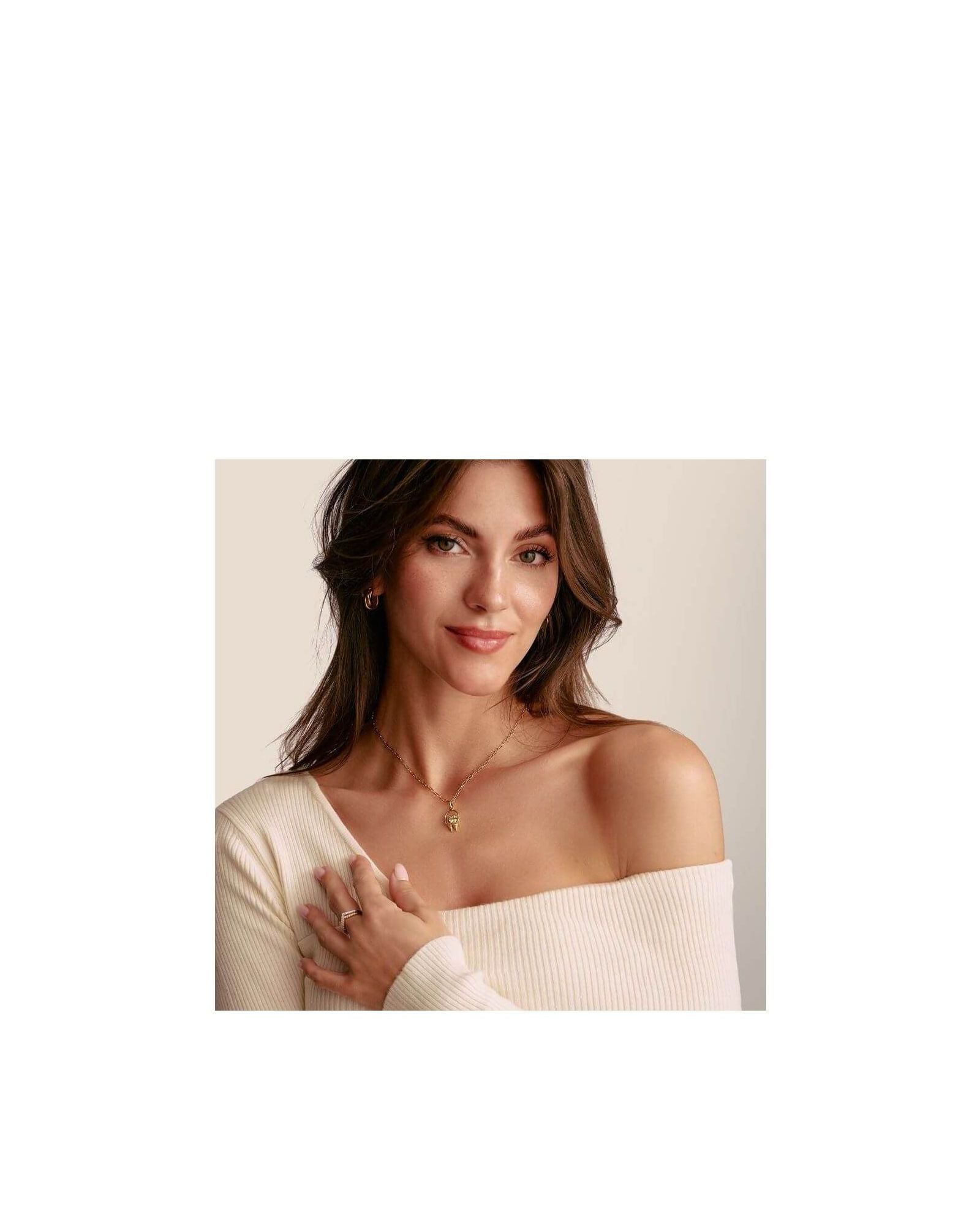 Woman wearing a charm pendant necklace featuring delicate birds and a heart, showcasing elegance and style.