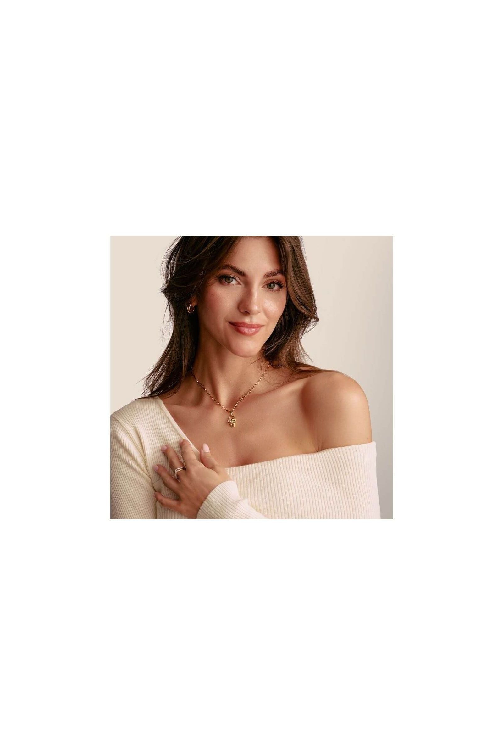 Woman wearing a charm pendant necklace featuring delicate birds and a heart, showcasing elegance and style.