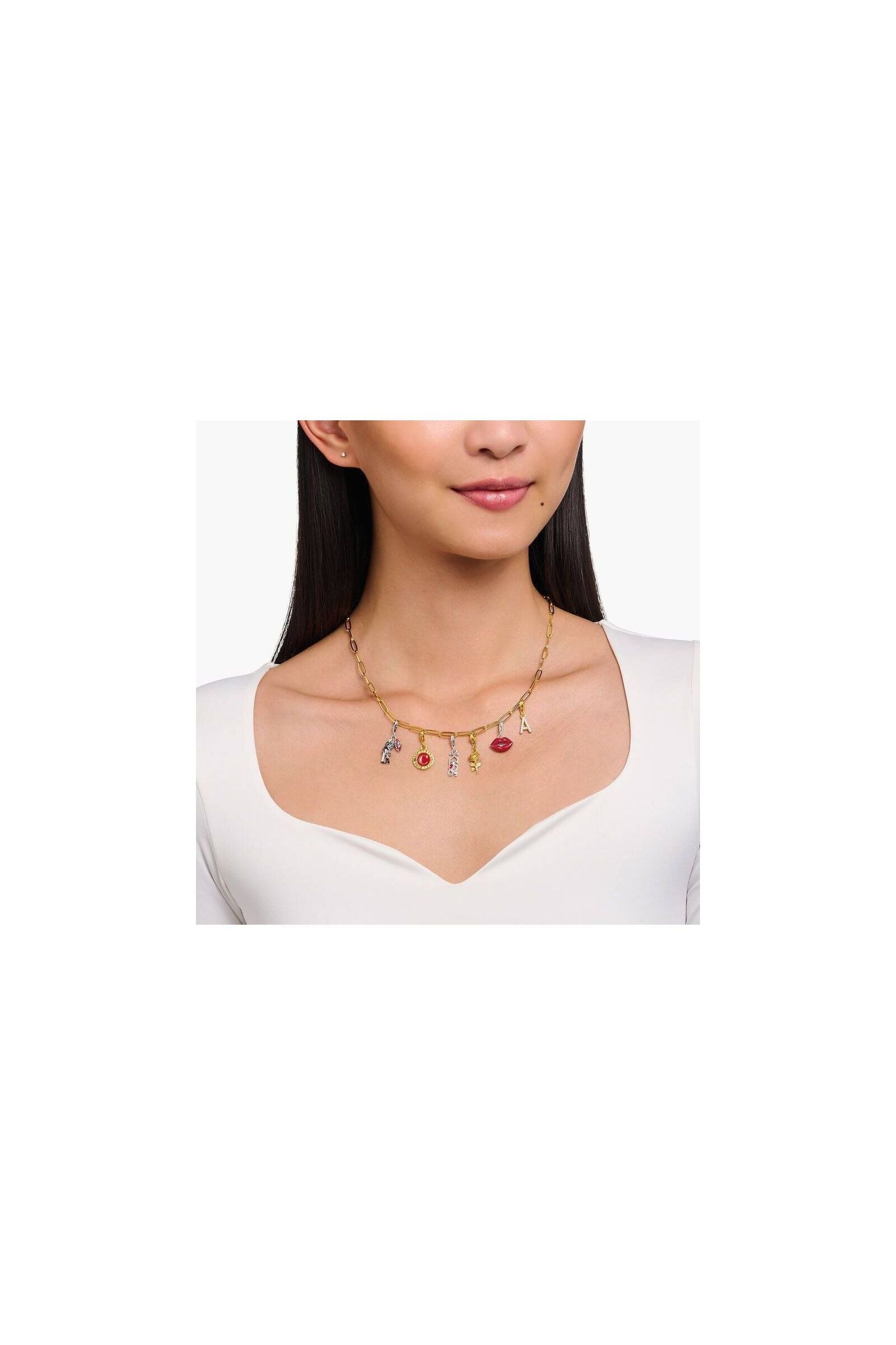 Collier en chaîne avec pendentifs charm, incluant une bouche en cœur rouge et d'autres breloques élégantes.