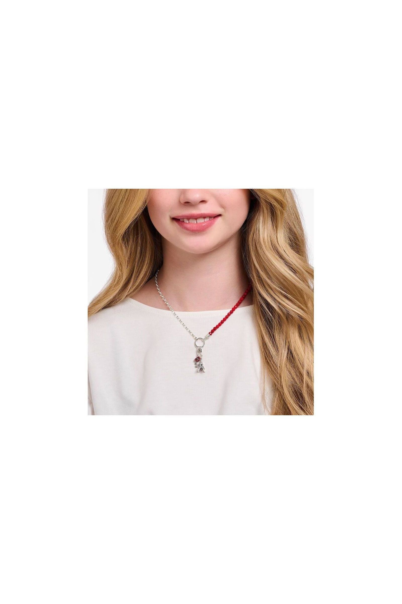 Femme portant un collier argenté avec un pendentif charm Tour Eiffel orné d'une zircone blanche.