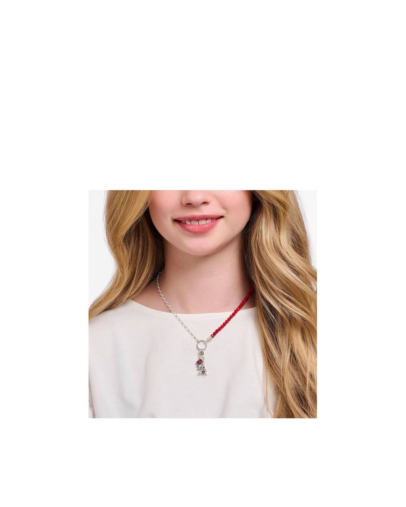 Femme avec un pendentif charm en argent et une rose rouge sur un collier élégant.