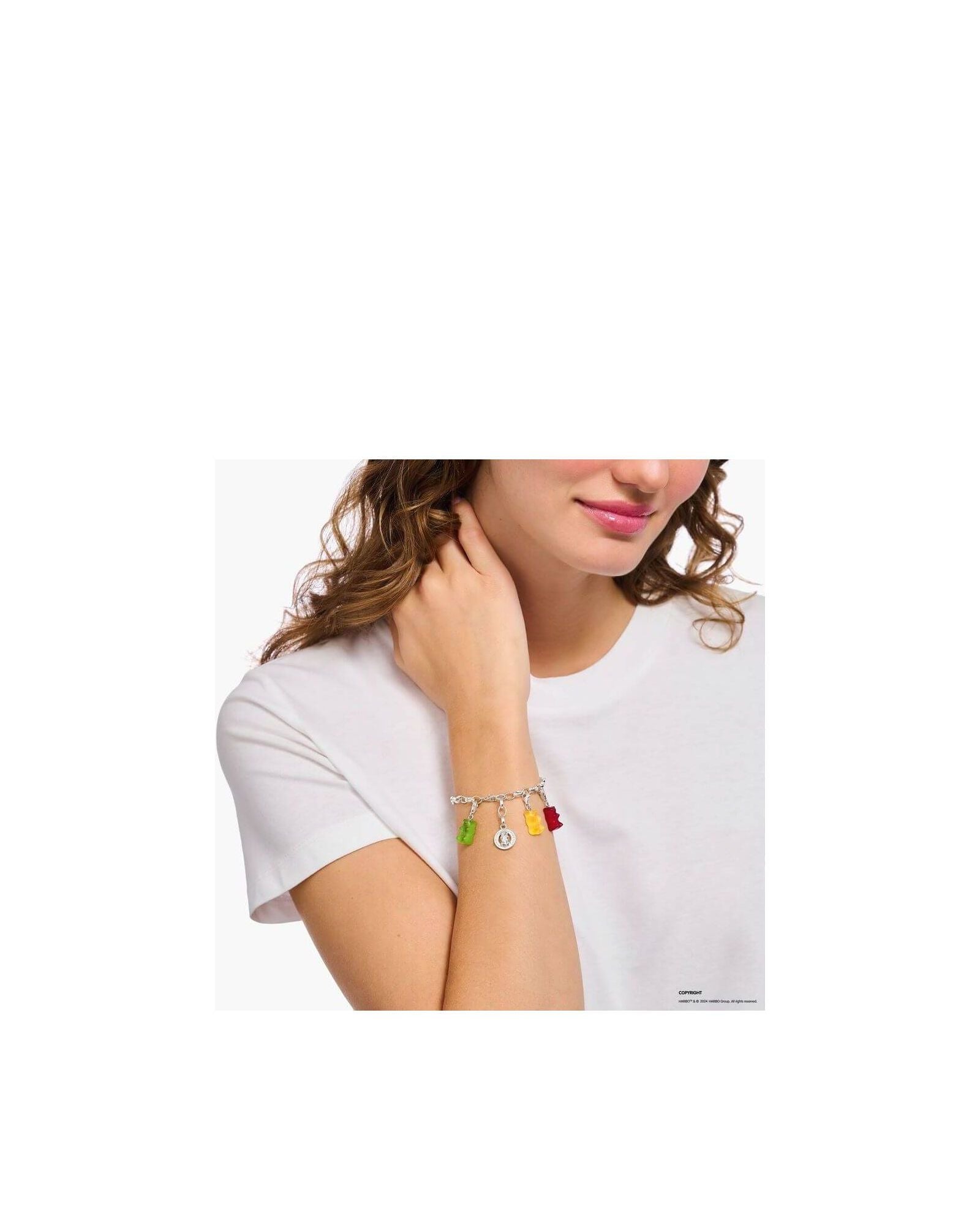 Bracelet charm with colorful gummy bear charms worn by a woman on her wrist, showcasing playful elegance.