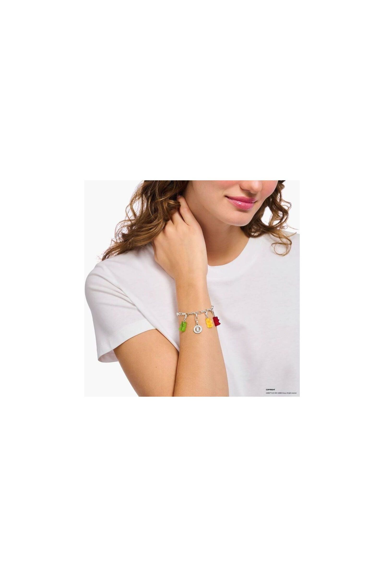 Bracelet charm with colorful gummy bear charms worn by a woman on her wrist, showcasing playful elegance.