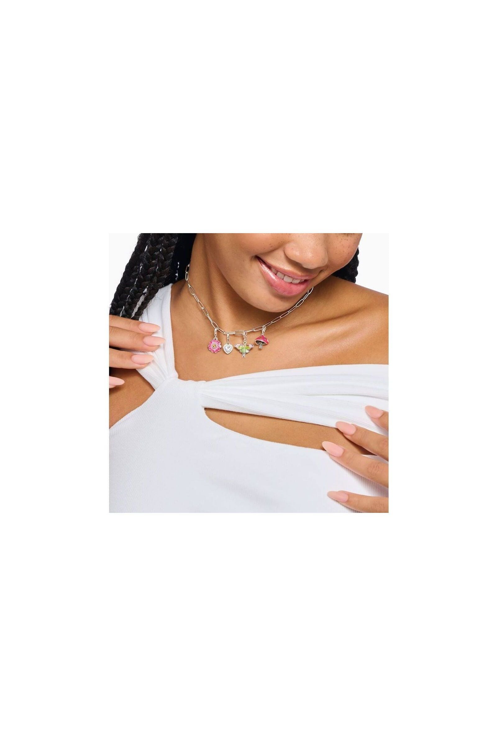 Femme portant un collier charm avec pendentifs floraux colorés, ajoutant une touche élégante à sa tenue.