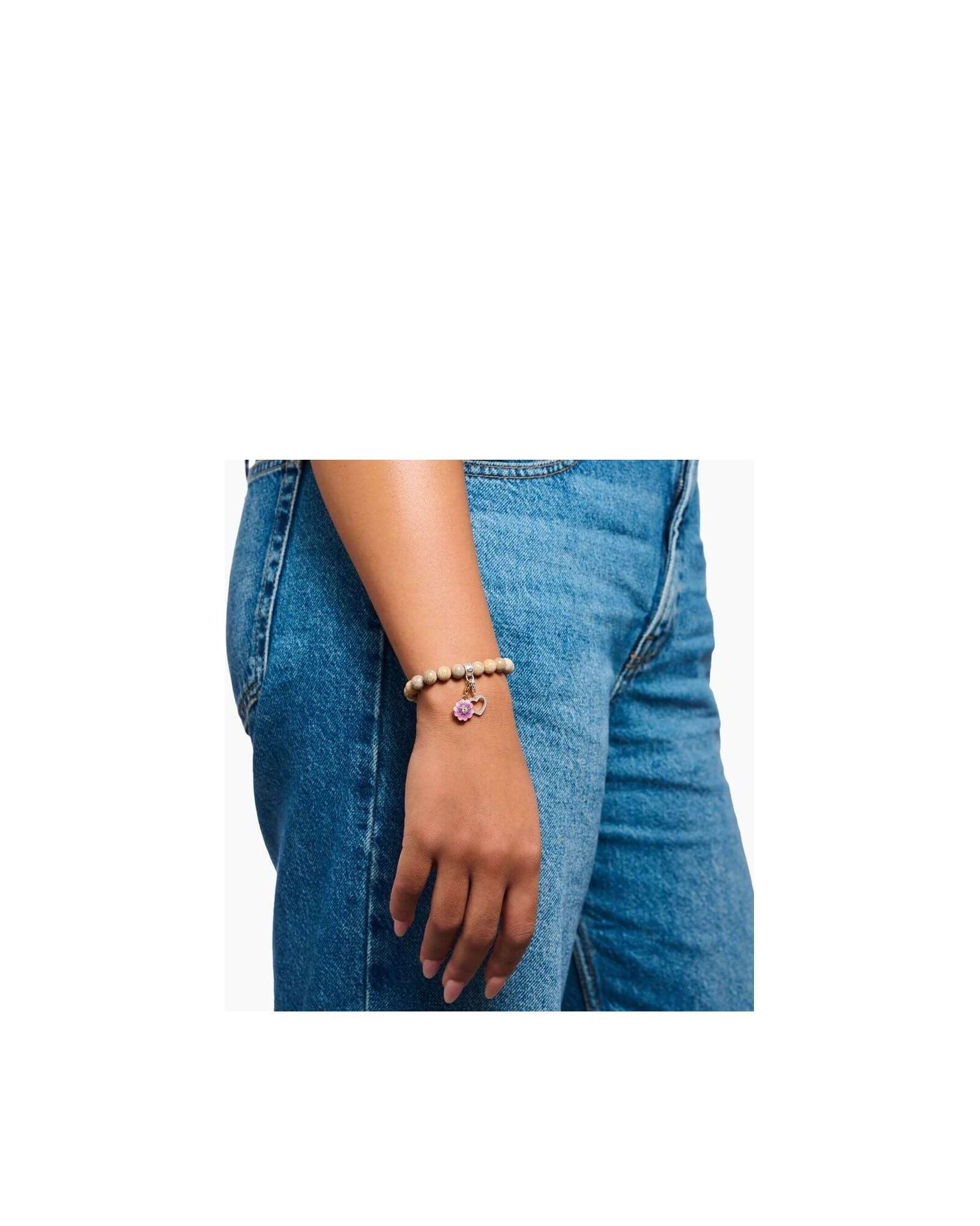Bracelet with pink charm on woman's wrist, featuring beads and floral design, perfect for Charm Club jewelry.