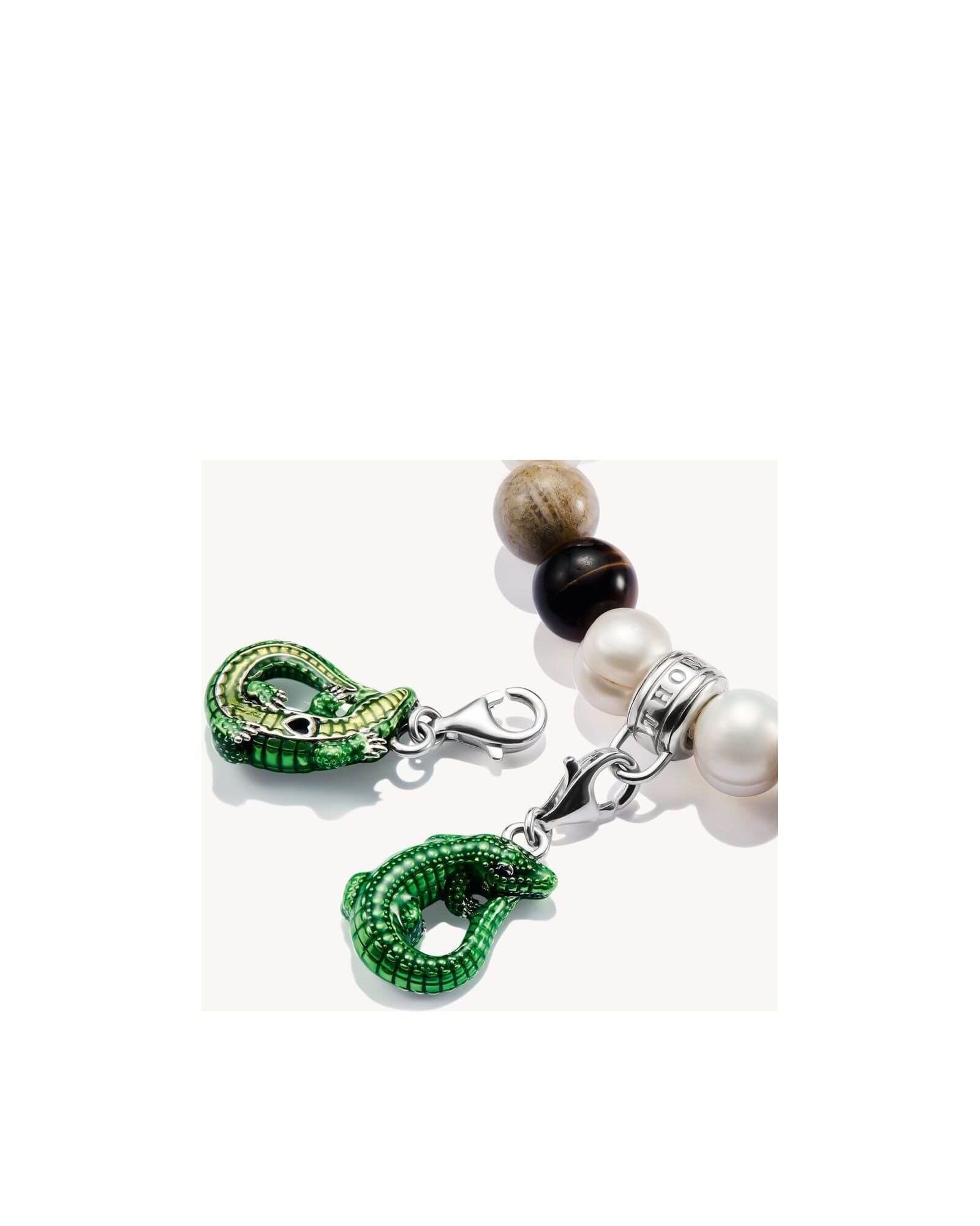 Charm pendant crocodile in green enamel, silver clasp on a beaded bracelet, highlighting elegance and eco-conscious design.