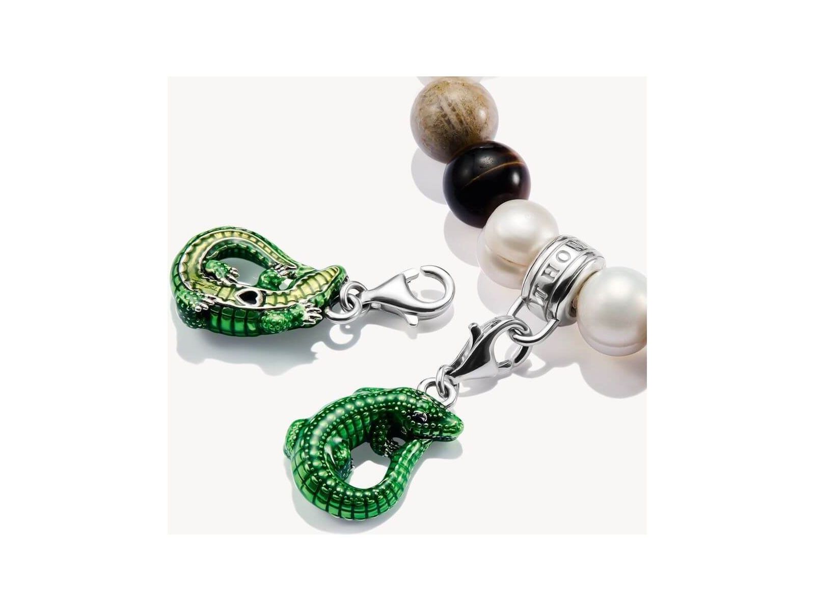Charm pendant crocodile in green enamel, silver clasp on a beaded bracelet, highlighting elegance and eco-conscious design.