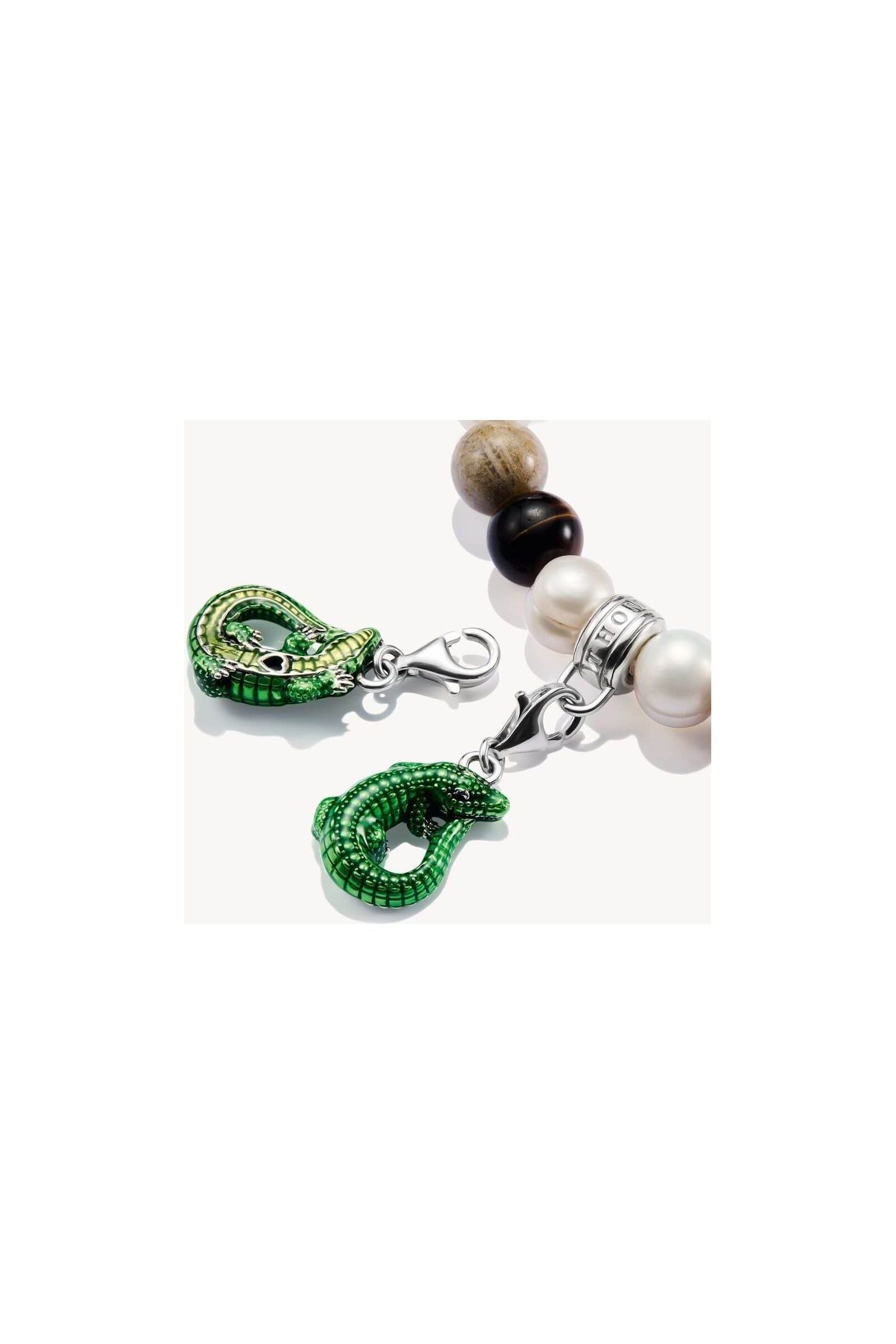 Charm pendant crocodile in green enamel, silver clasp on a beaded bracelet, highlighting elegance and eco-conscious design.