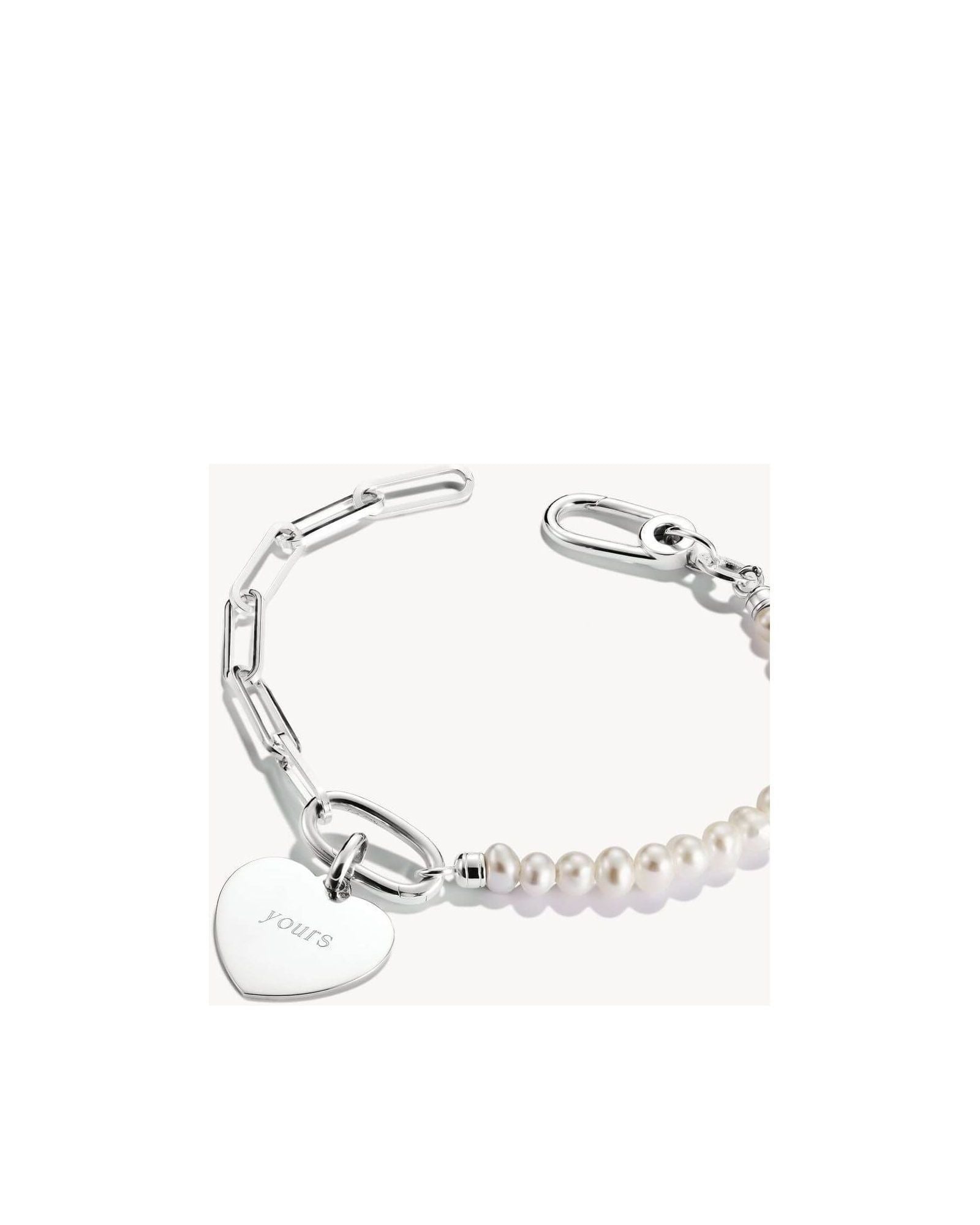 Pendentif charm en argent en forme de cœur avec perles, gravé 'yours', sur bracelet élégant.