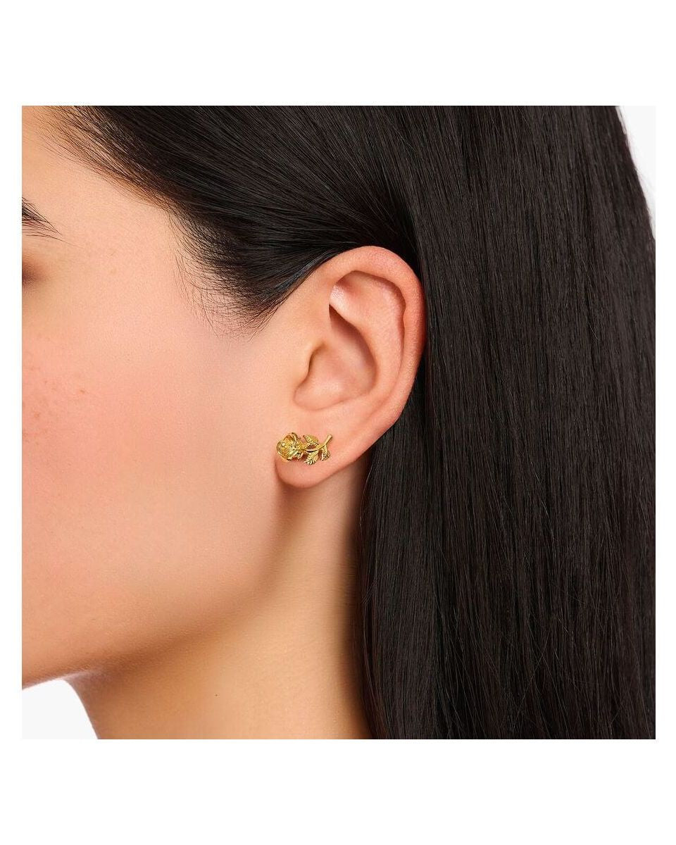 Clous d'oreilles Roses Romance plaqué or sur l'oreille d'une femme, avec un design en forme de rose en argent recyclé.