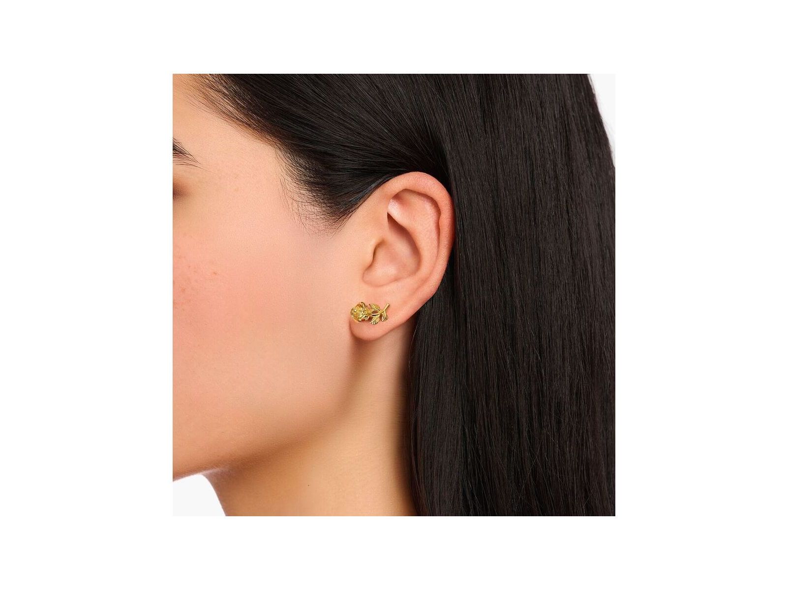Clous d'oreilles Roses Romance plaqué or sur l'oreille d'une femme, avec un design en forme de rose en argent recyclé.