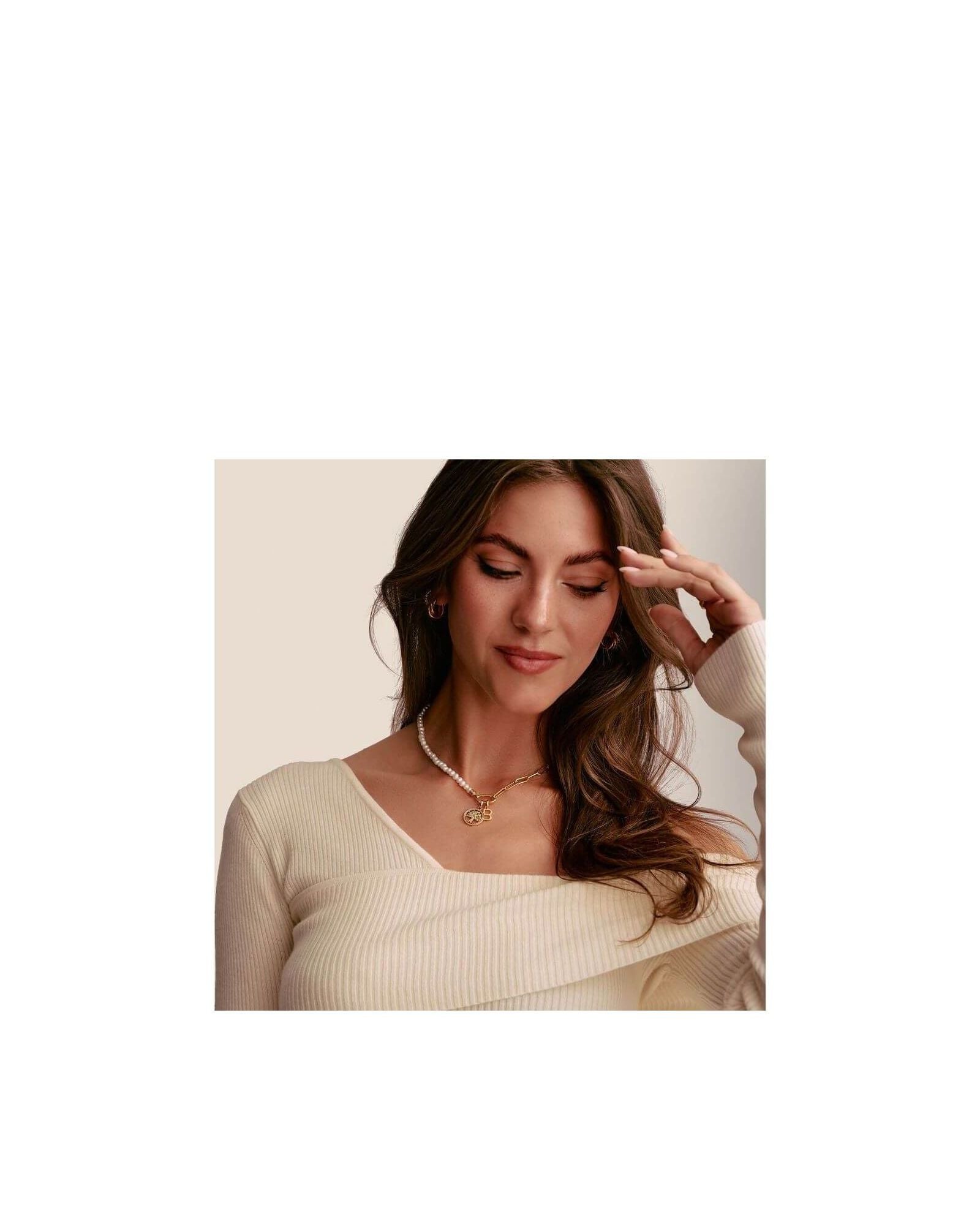 Model showcasing a delicate gold tree of love charm pendant adorned with white zirconium stones.