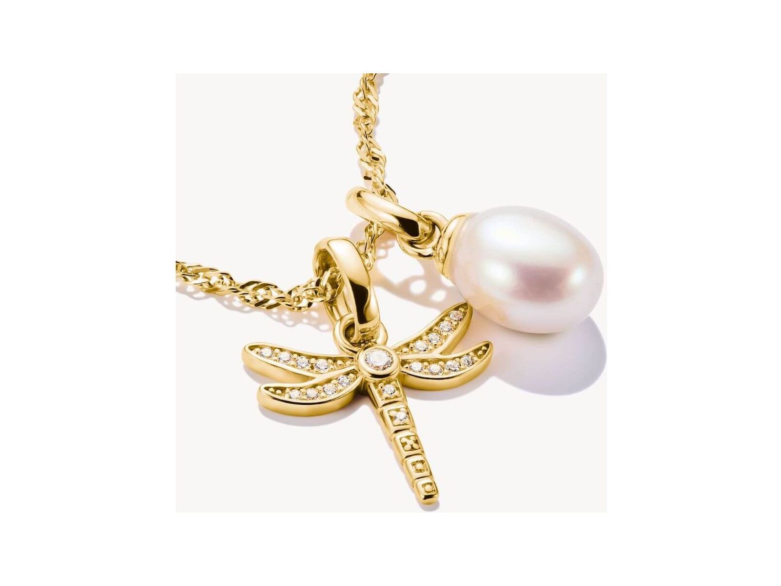 Pendentif charm libellule plaqué or avec pierres blanches et perle, élégant bijou nature.