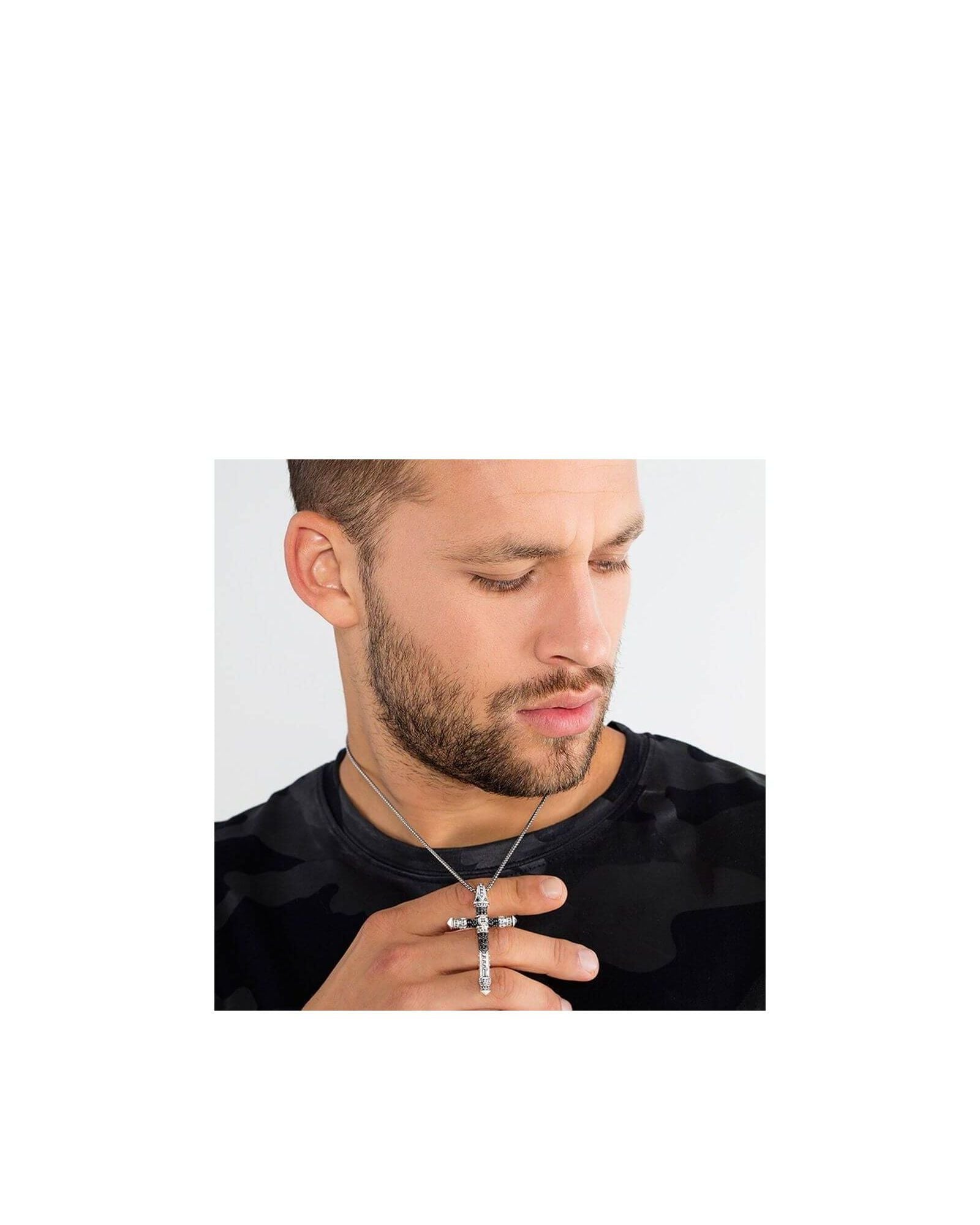 Homme portant un pendentif croix en argent avec une chaîne, affichant un look tendance et moderne.