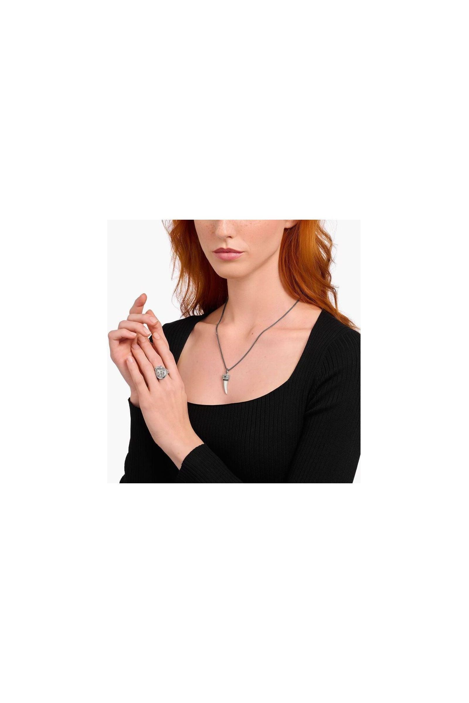 Modèle portant une chaîne à breloque dent ornée de gemmes en argent noirci avec un élégant design.