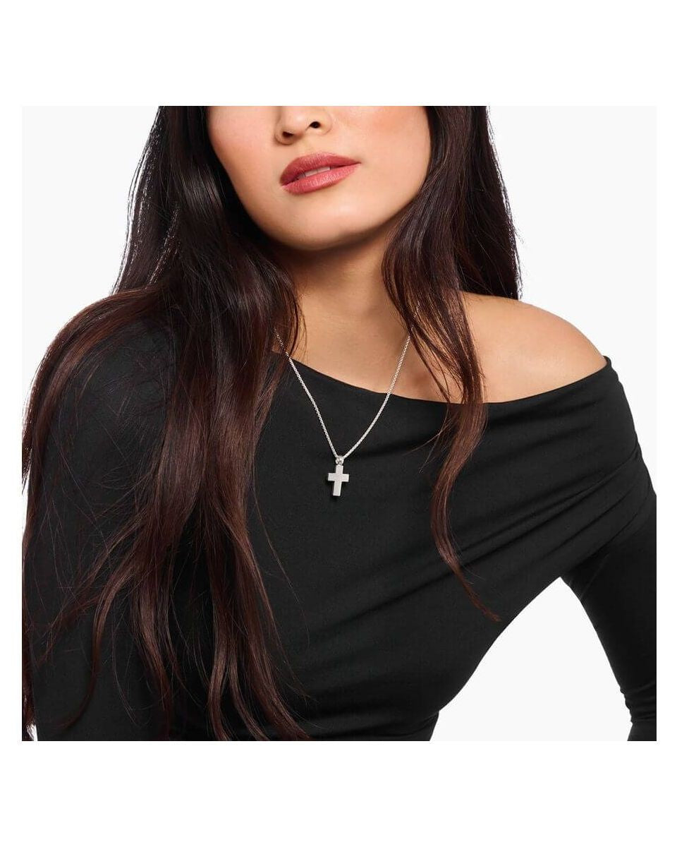 Woman wearing a handmade silver cross pendant on a delicate chain, showcasing classic minimalist style.