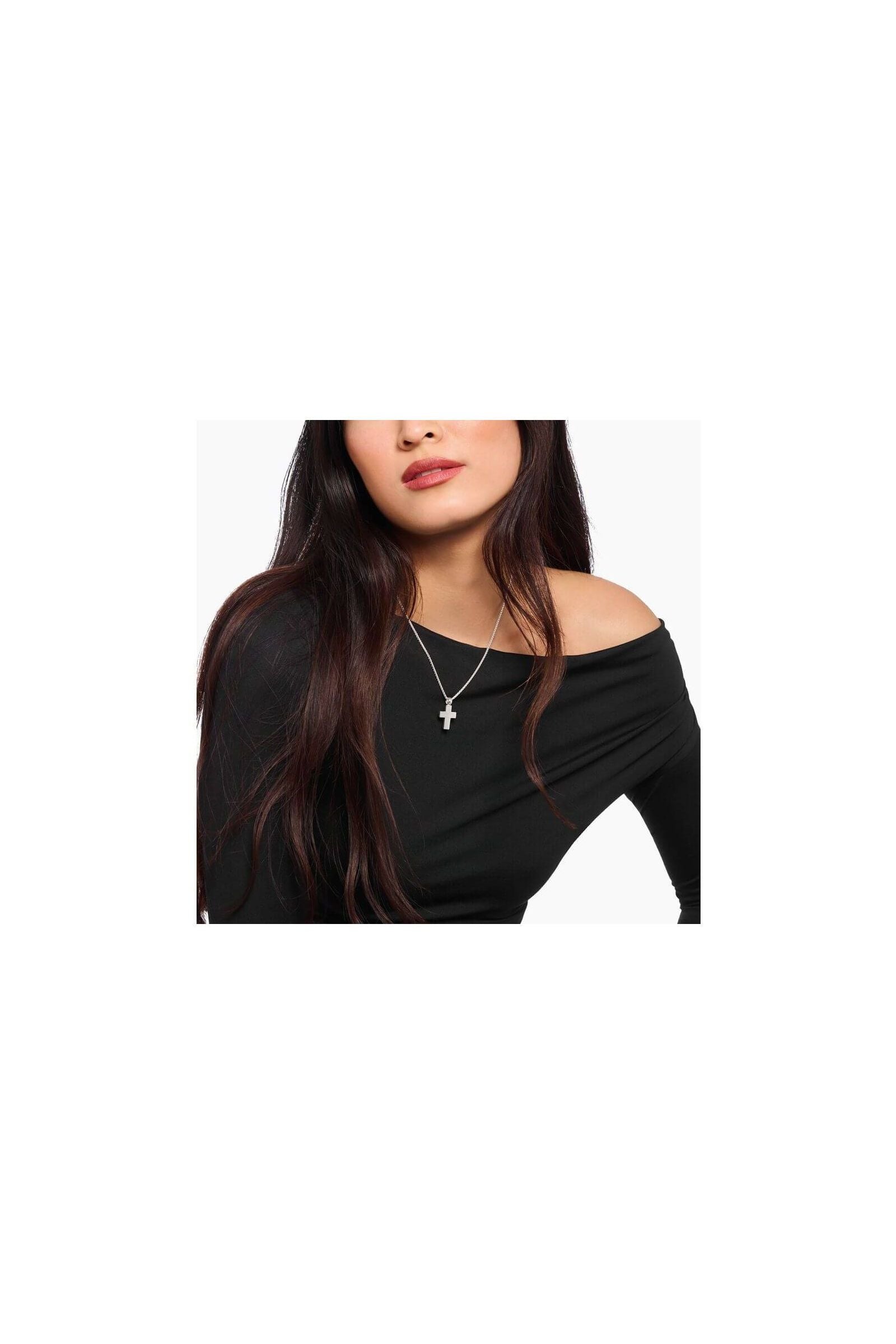 Woman wearing a handmade silver cross pendant on a delicate chain, showcasing classic minimalist style.