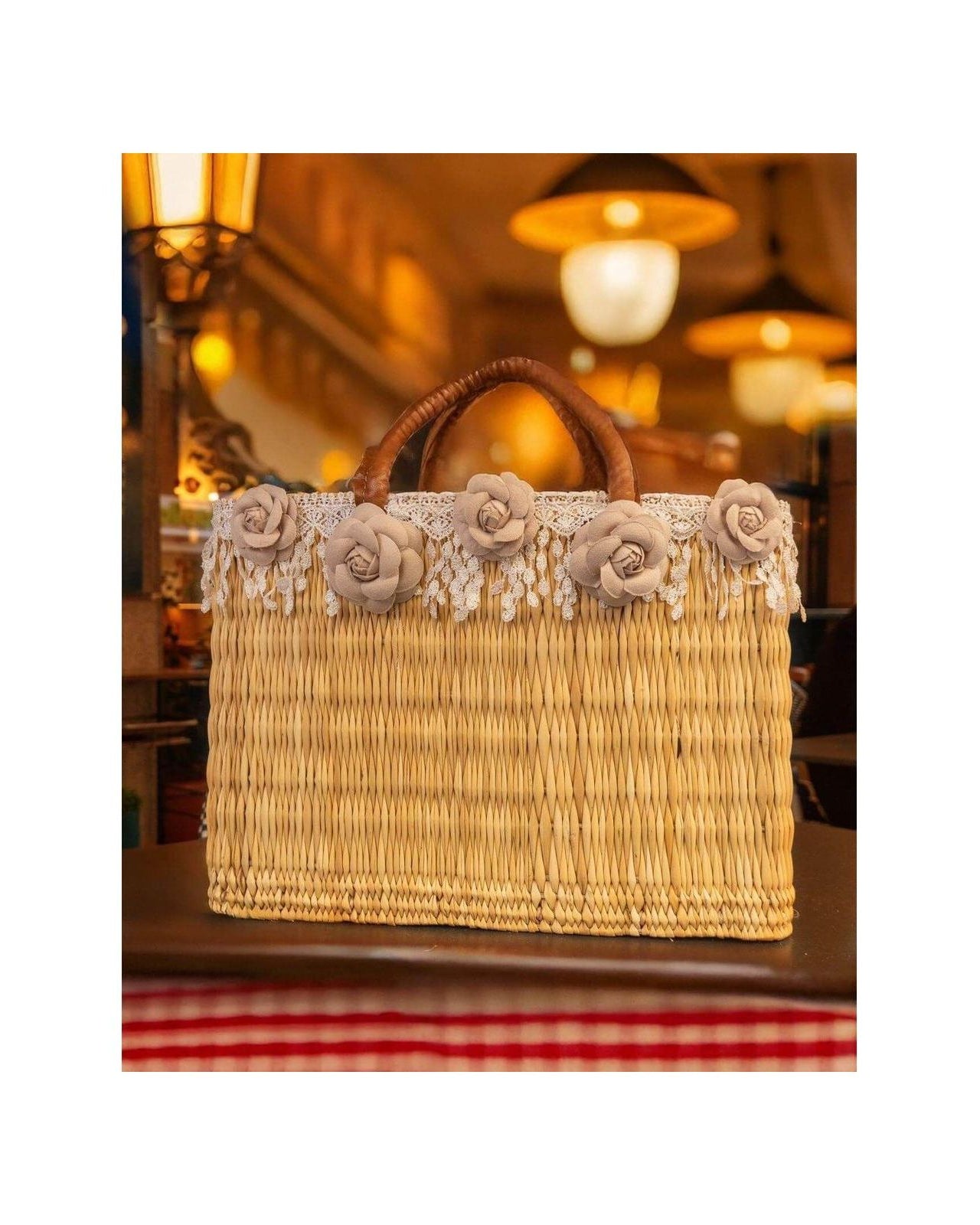 Panier en osier décoré de fleurs colorées et franges, idéal pour un look estival élégant et tendance.