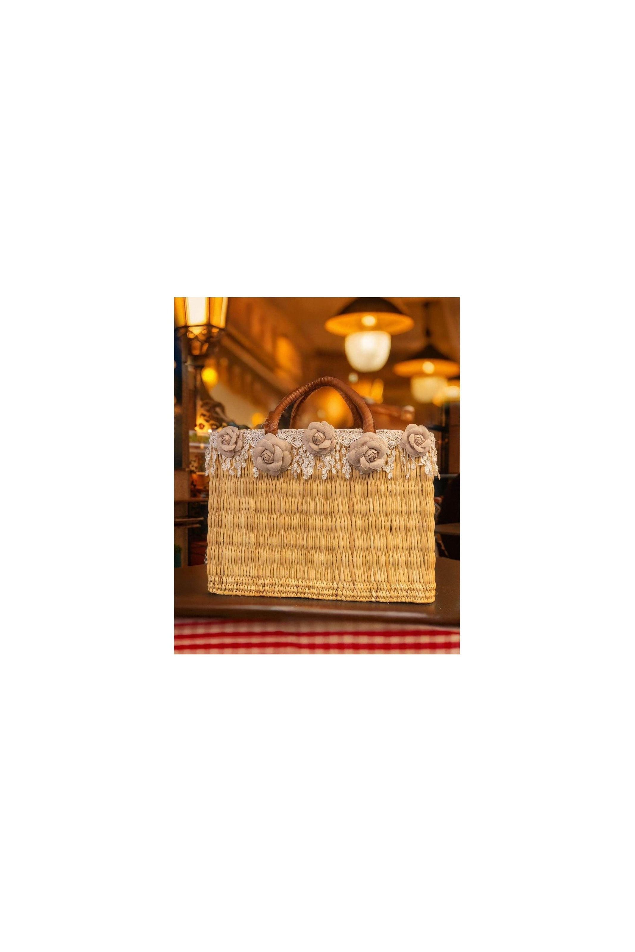 Panier en osier décoré de fleurs colorées et franges, idéal pour un look estival élégant et tendance.
