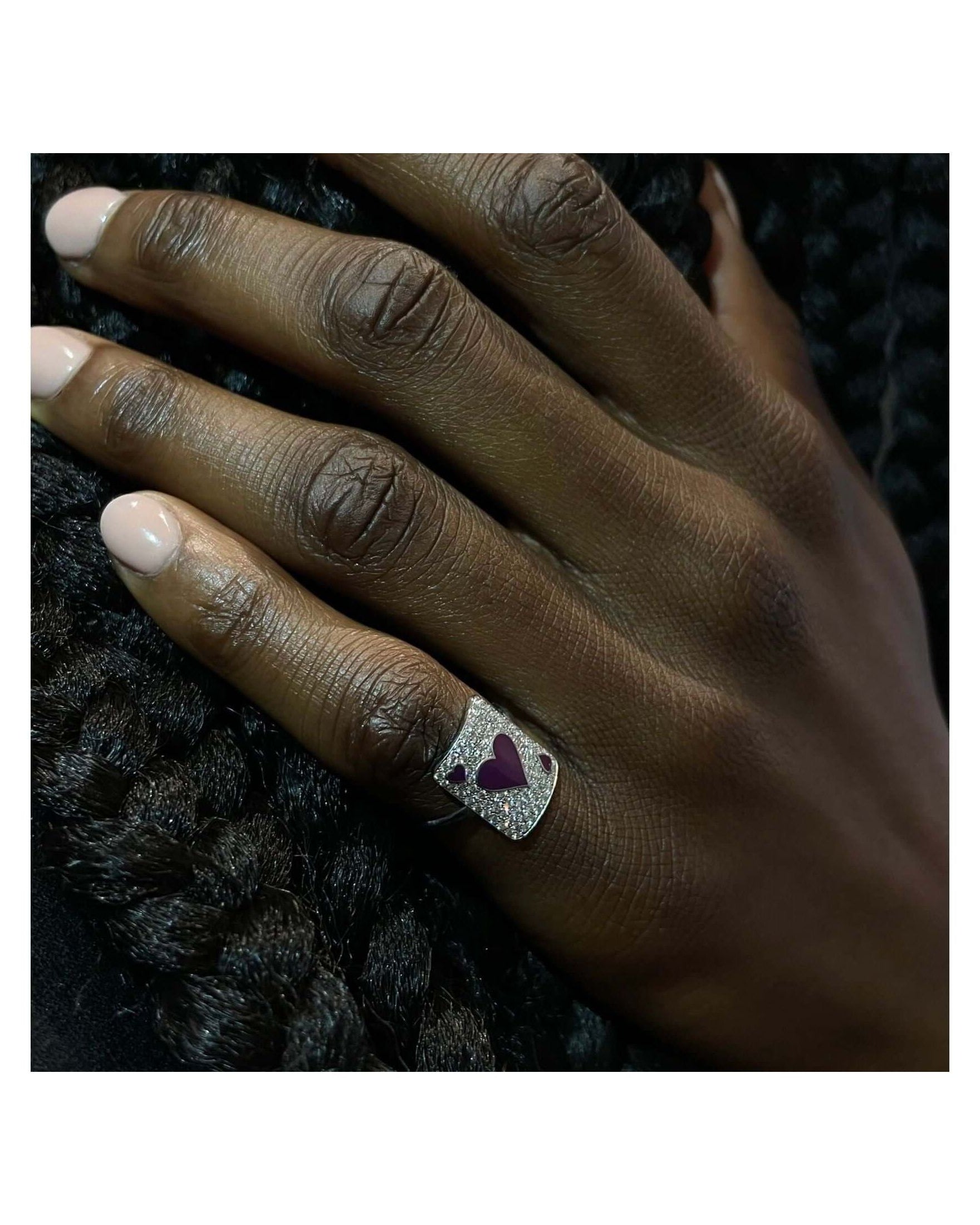 Hand wearing the Bague Pinkie Lovely Âme ring featuring a heart design, showcasing its elegant craftsmanship.