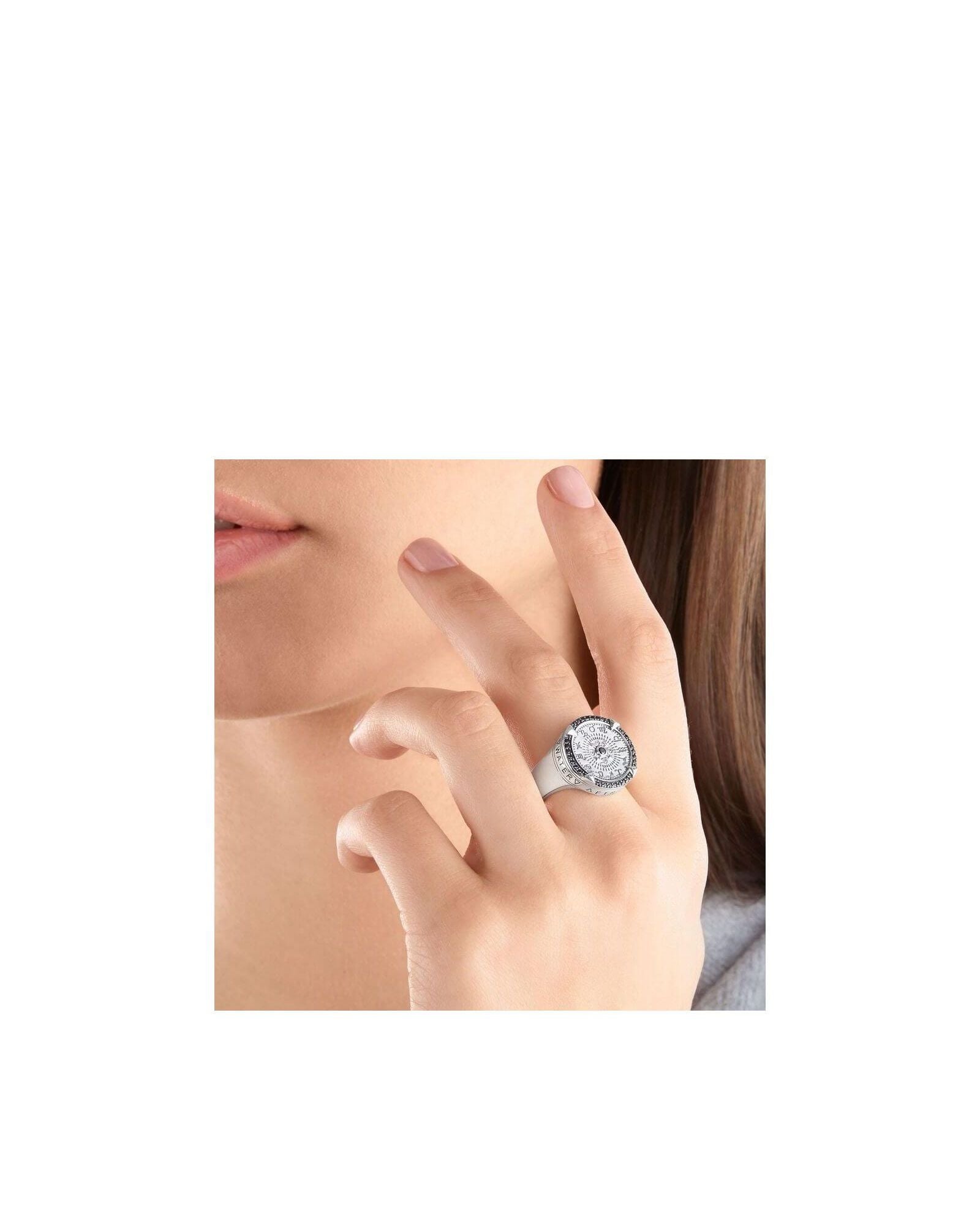 Woman wearing Bague Elements of Nature sterling silver ring featuring zodiac signs and engraved elements.