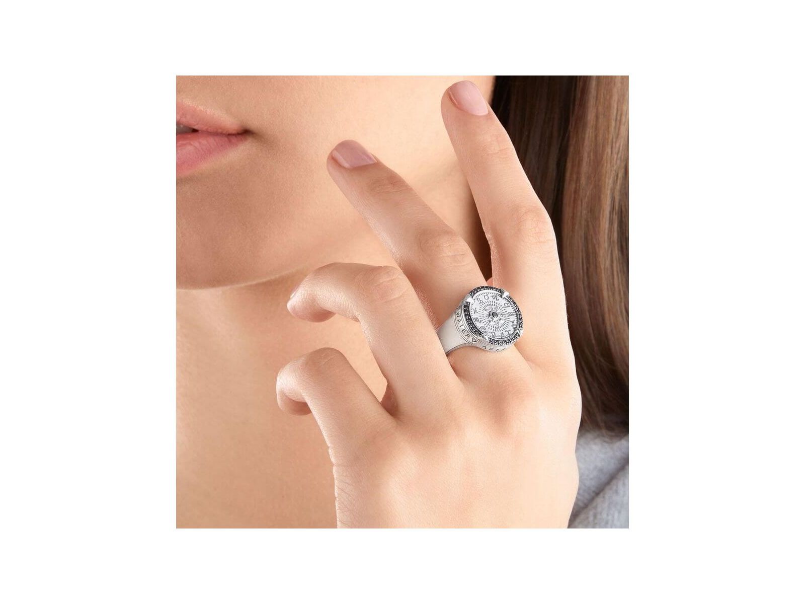 Woman wearing Bague Elements of Nature sterling silver ring featuring zodiac signs and engraved elements.