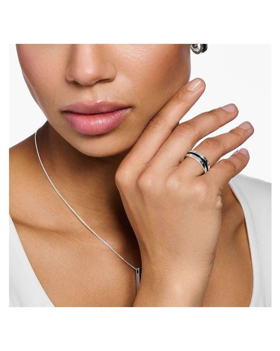 Femme portant une bague ruban en argent avec pierres noires, mettant en valeur son élégance et son style.