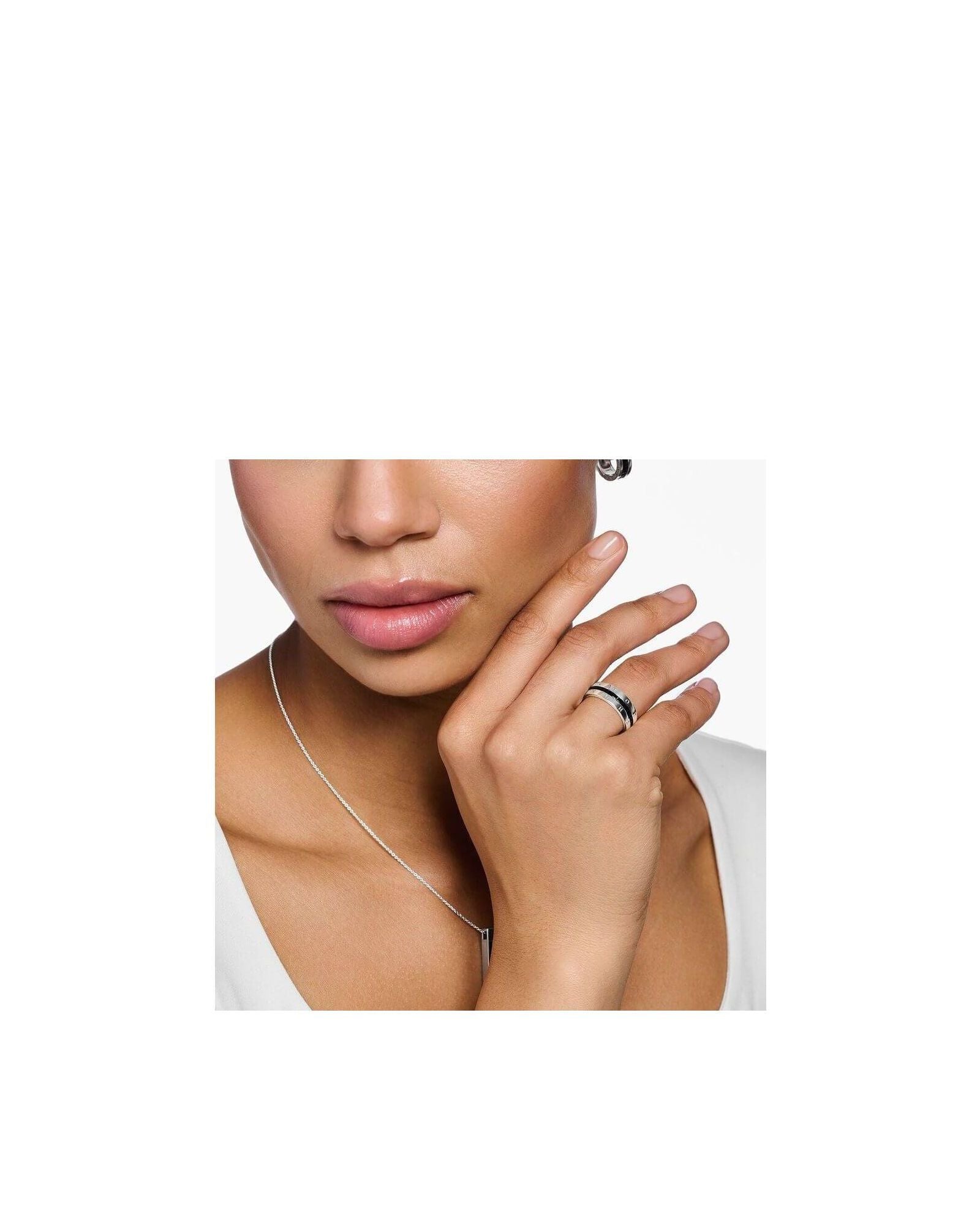 Femme portant une bague ruban en argent avec pierres noires, mettant en valeur son élégance et son style.