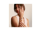 Femme portant un bracelet avec pendentif médaille Connect Charm en argent recyclé, mettant en valeur un style élégant.