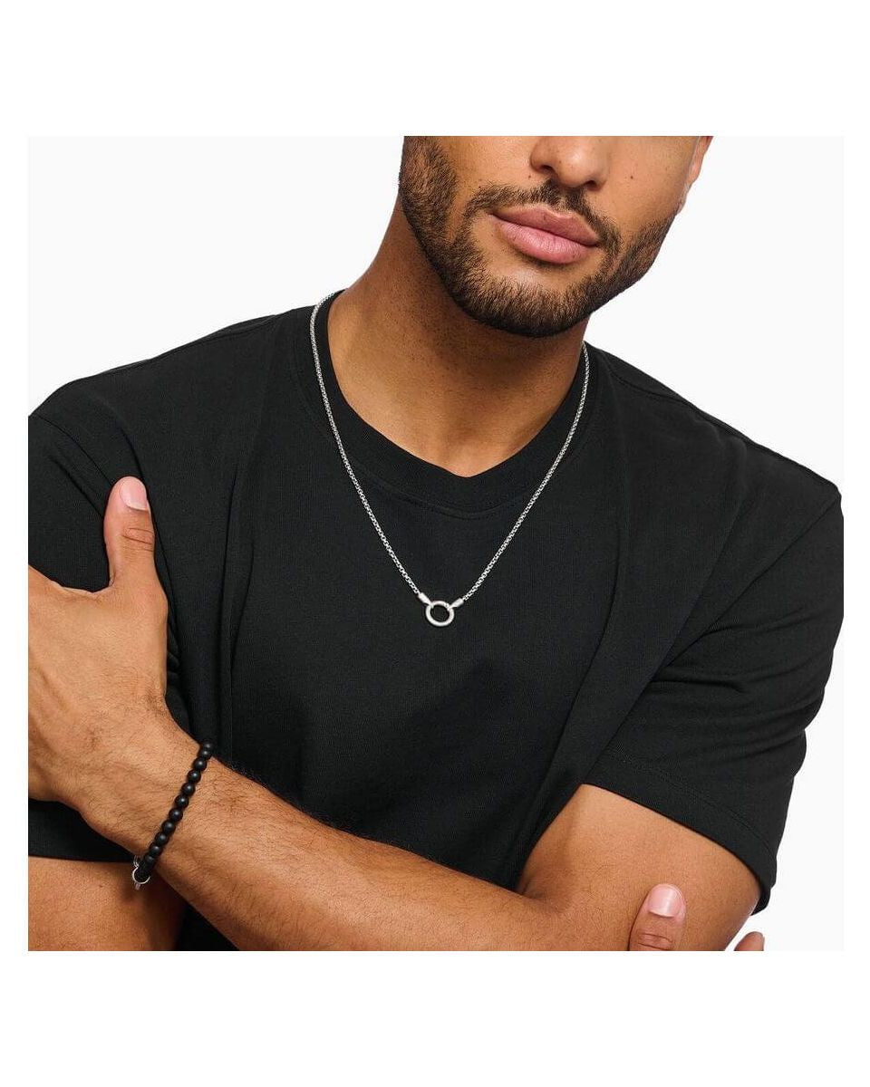 Homme portant un collier vénitien en argent avec fermoir rond, style minimaliste sur t-shirt noir.