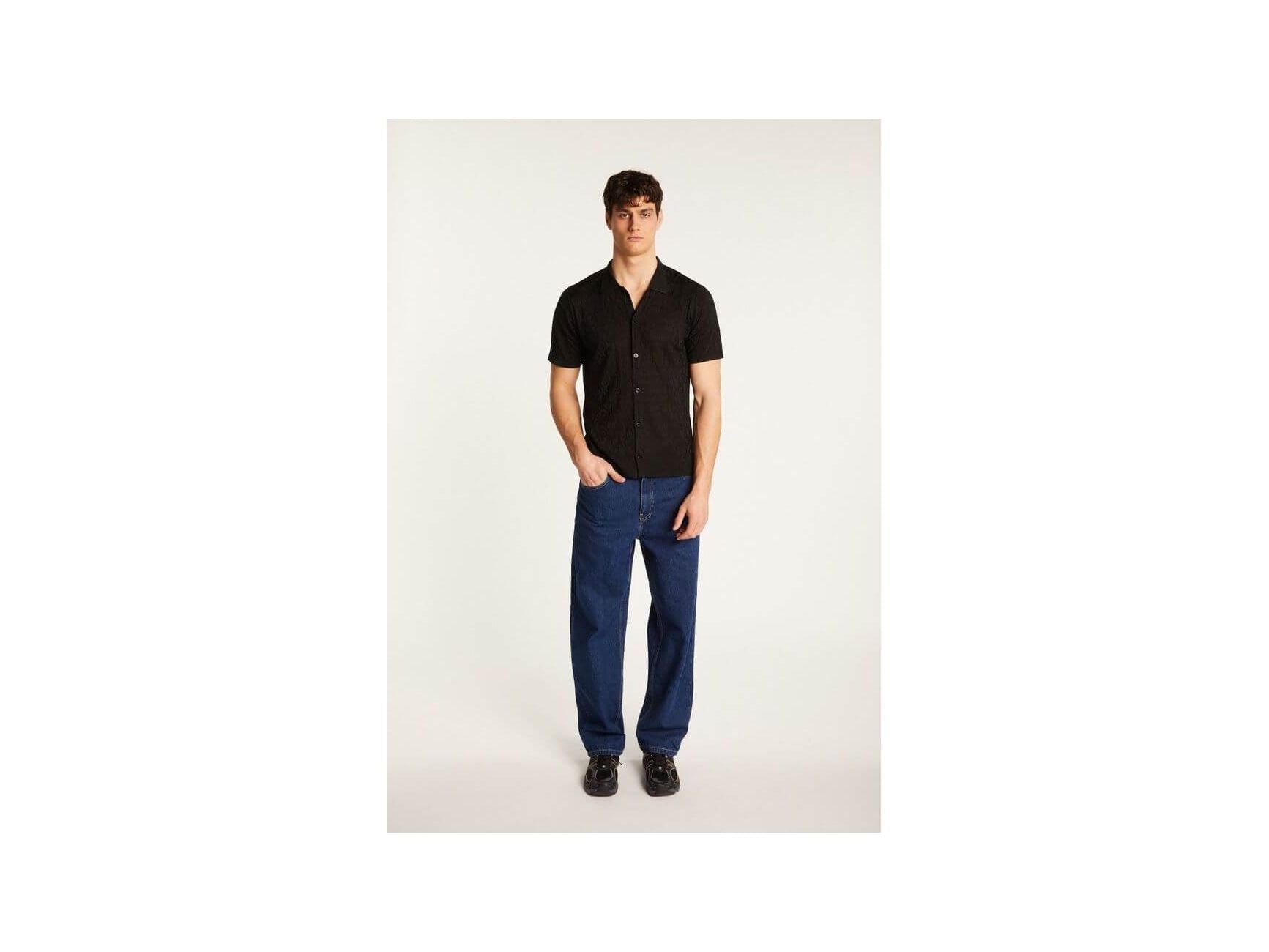 Homme portant une chemise Matthew en polyamide, avec un look moderne et élégant, accompagné de pantalons bleu.