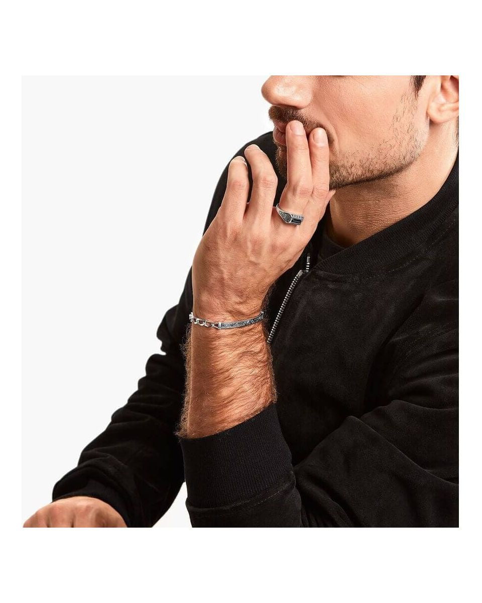 Modèle masculin portant une bague collège en argent et un bracelet, mettant en avant le style contemporain et élégant.