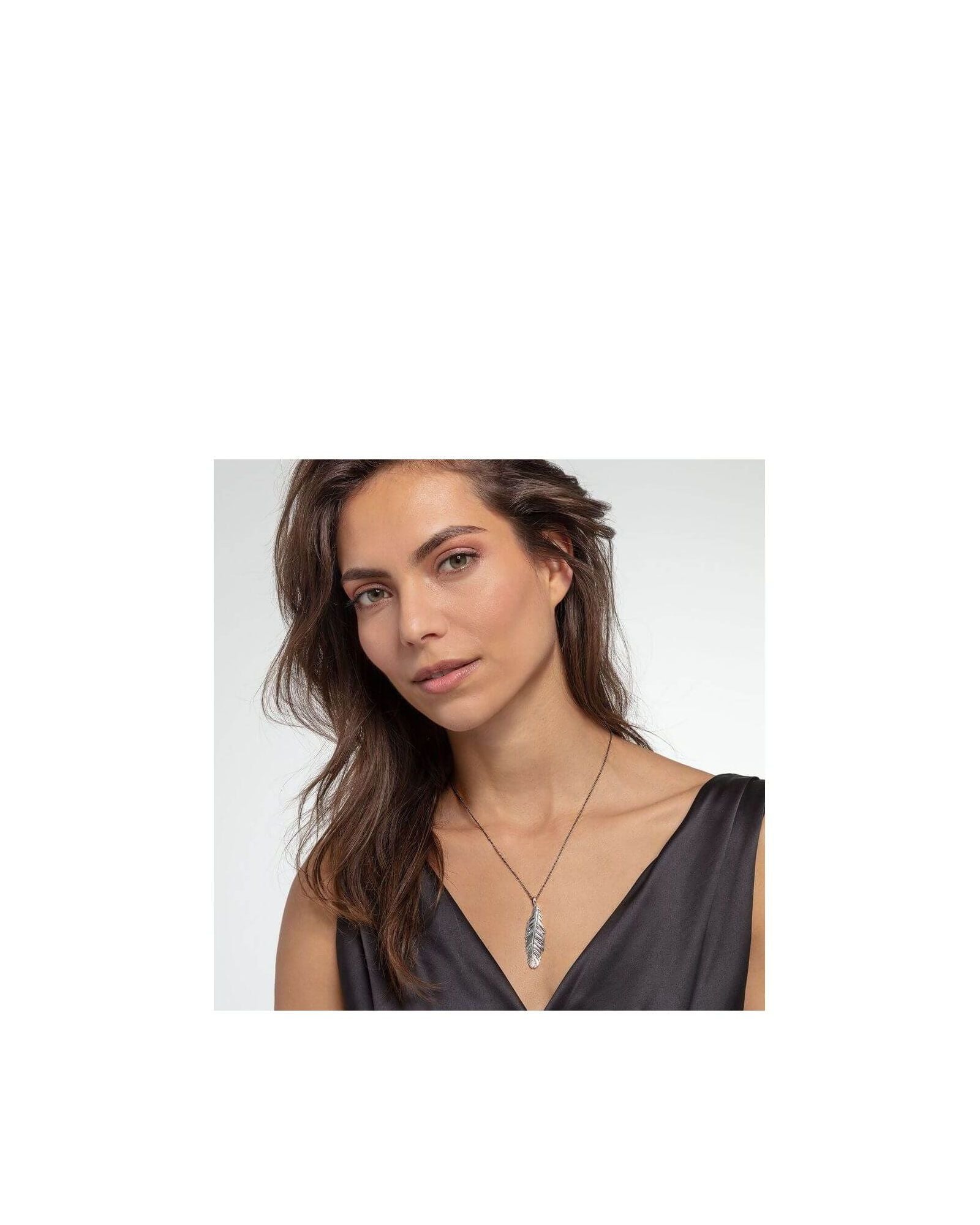 Femme portant le pendentif plume en argent sterling noirci de THOMAS SABO, mettant en avant son élégance.
