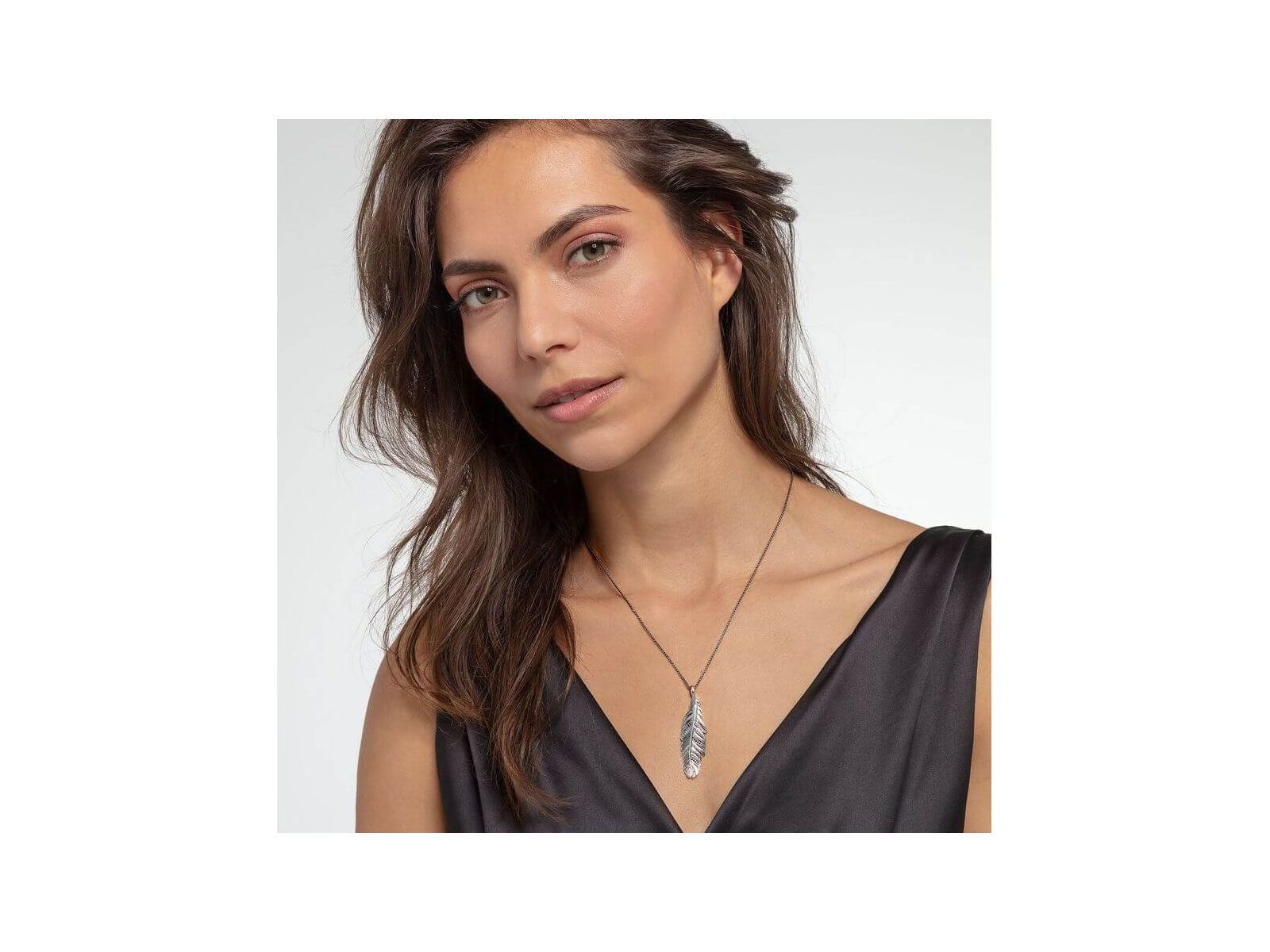 Femme portant le pendentif plume en argent sterling noirci de THOMAS SABO, mettant en avant son élégance.