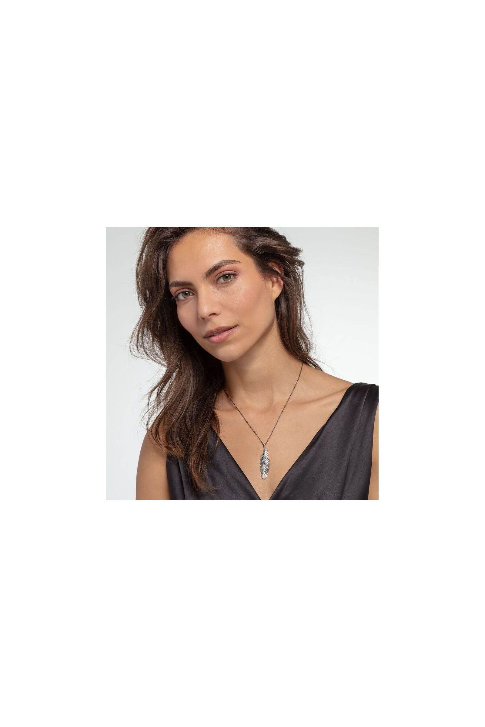 Femme portant le pendentif plume en argent sterling noirci de THOMAS SABO, mettant en avant son élégance.