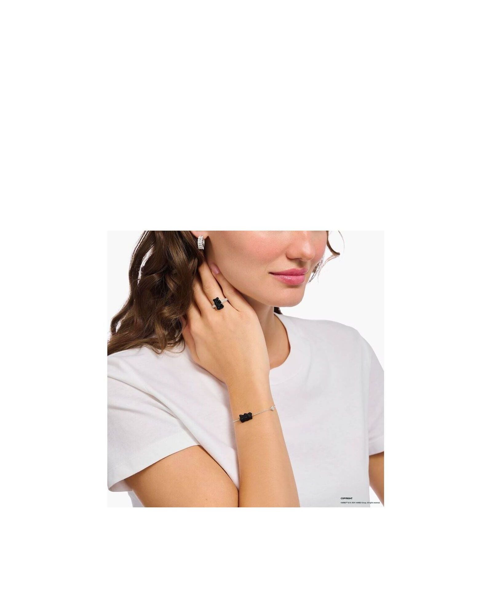 Woman wearing a stylish adjustable bracelet with a black satin crystal bear pendant and freshwater pearl.
