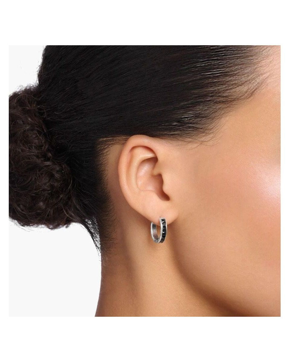 Créoles en argent sterling avec zircones noires, portées sur l'oreille, élégantes et modernes.