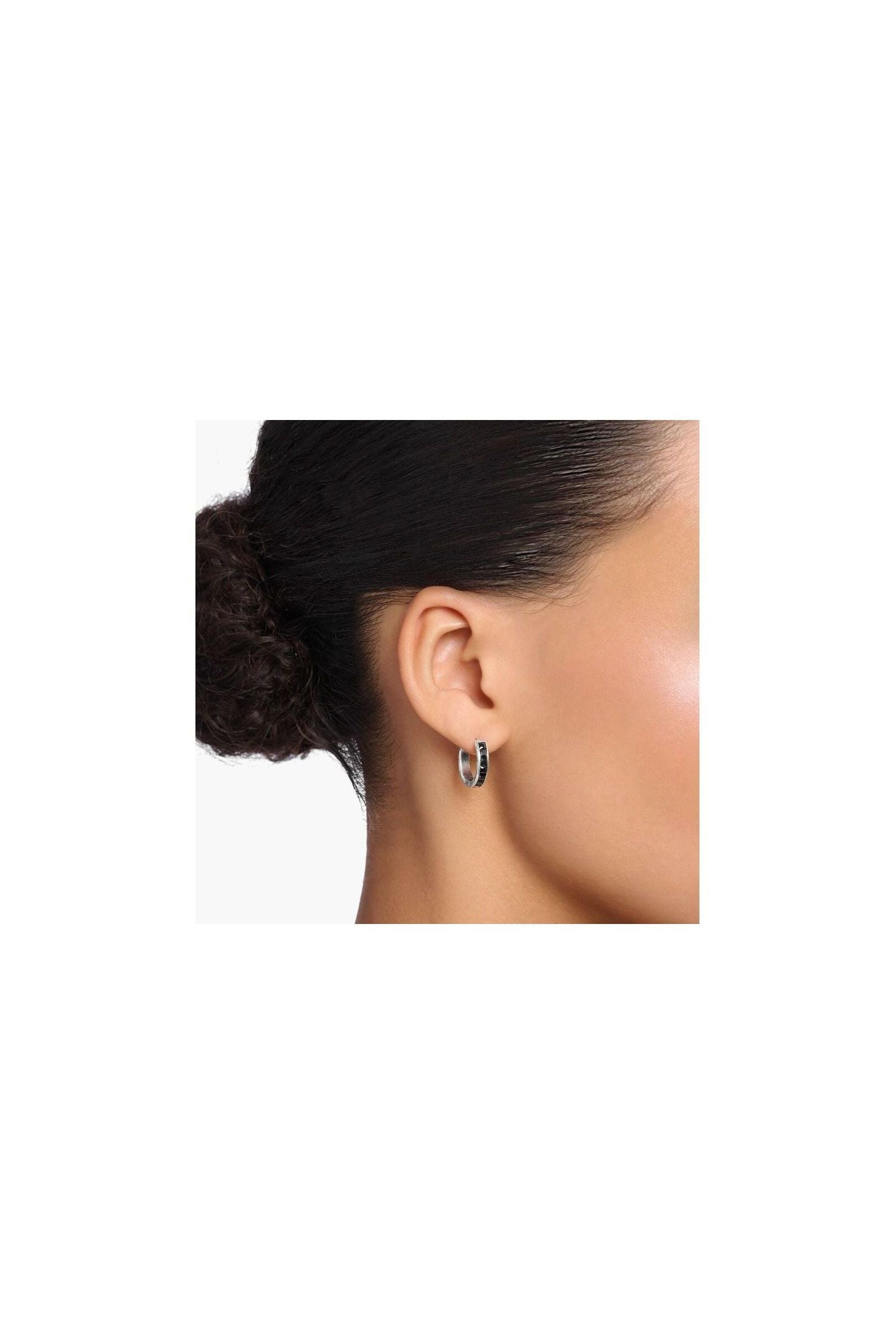 Créoles en argent sterling avec zircones noires, portées sur l'oreille, élégantes et modernes.