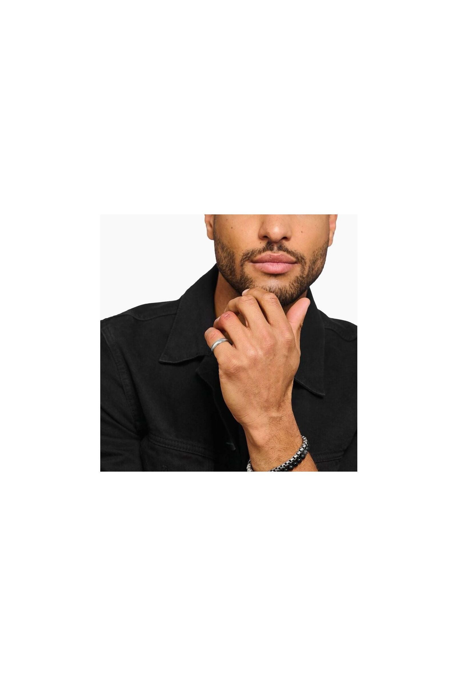 Man wearing a sleek silver band ring and bracelets, showcasing minimalist jewelry style.