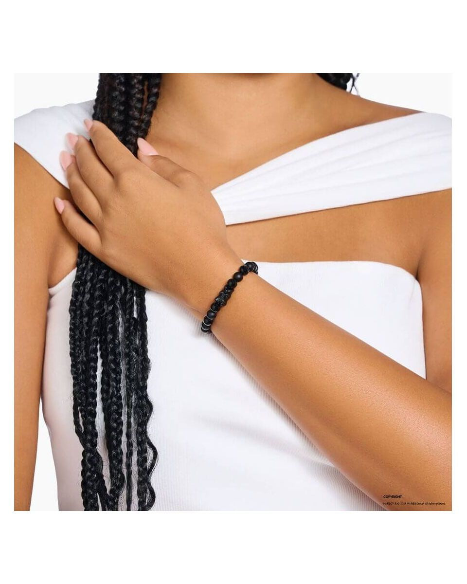 Bracelet en beads d'obsidienne noire avec ours en cristal noir, porté sur un poignet féminin.