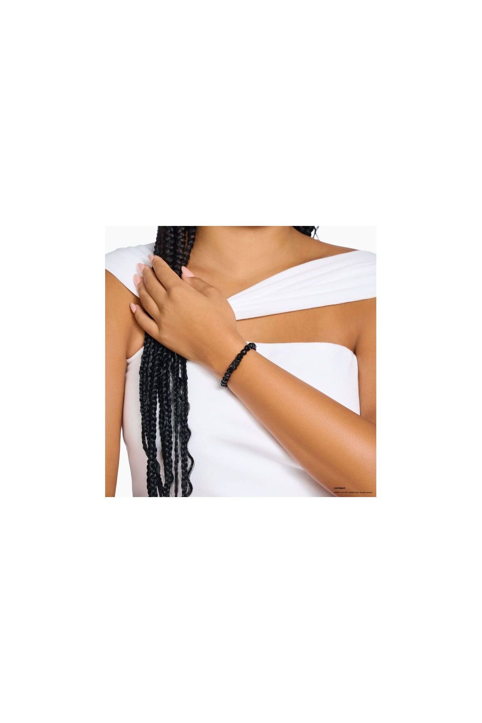 Bracelet en beads d'obsidienne noire avec ours en cristal noir, porté sur un poignet féminin.