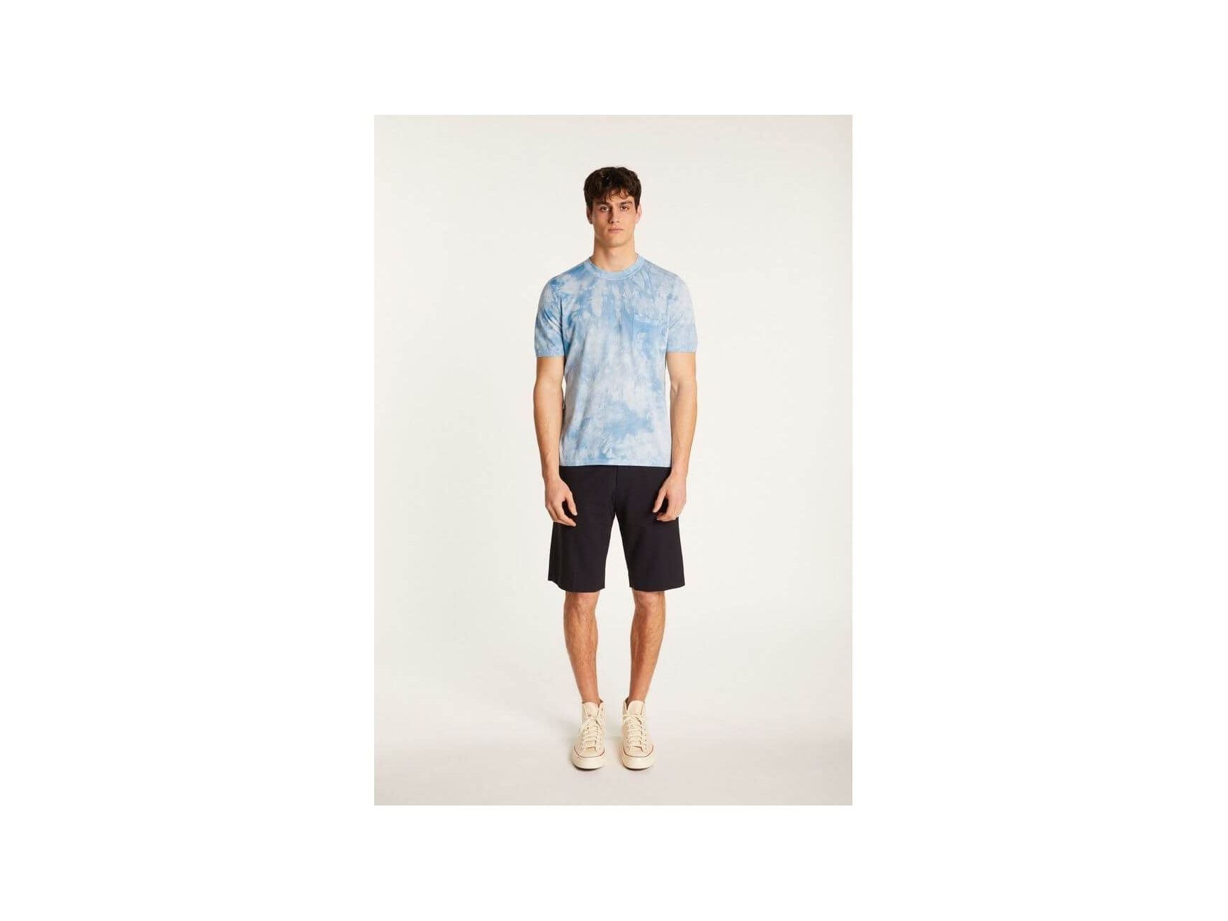 Homme portant un T-Shirt Marquez bleu ciel en coton biologique, associé à un short noir, style décontracté.