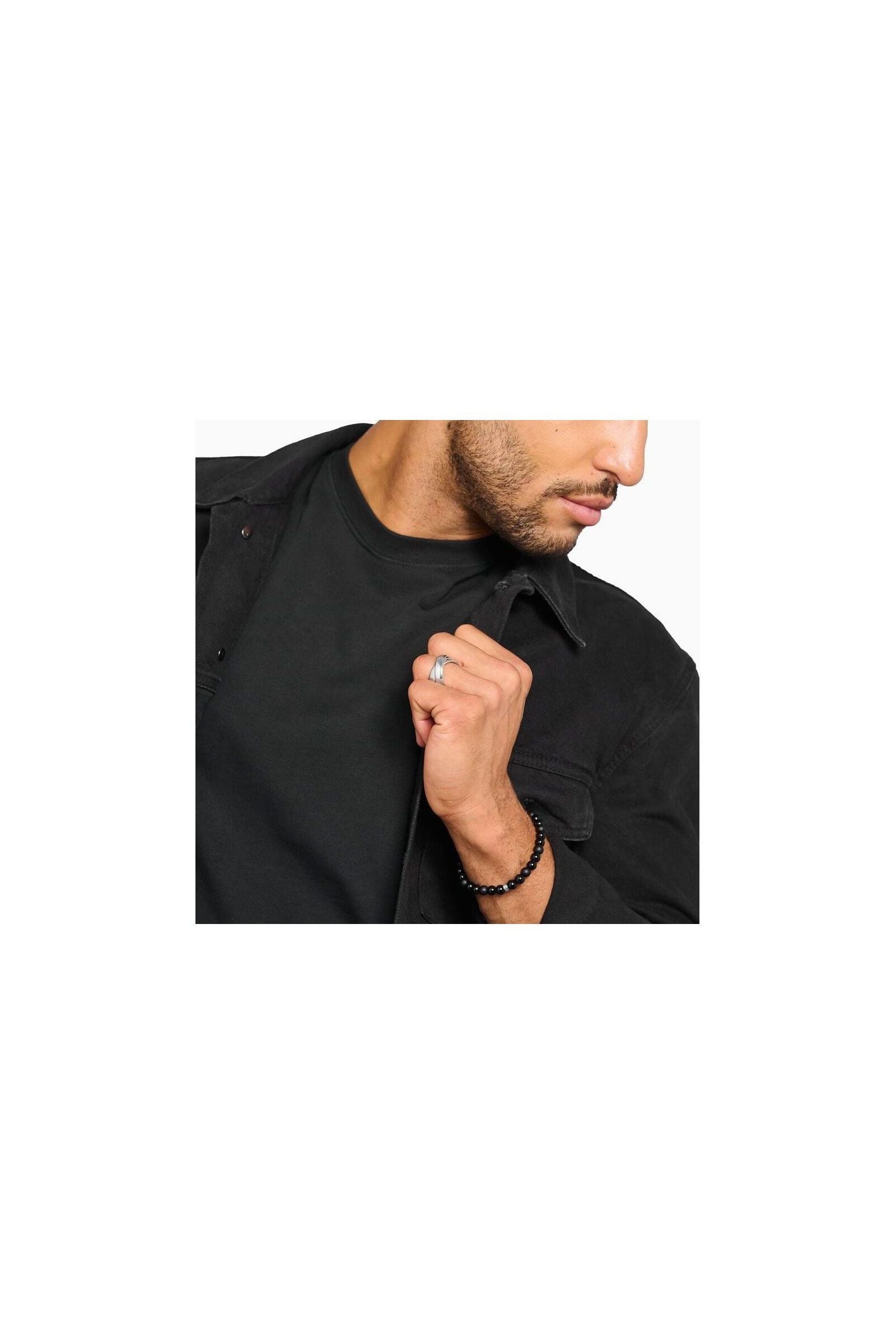 Homme portant la bague duo large en argent, avec un bracelet en perles, style élégant et moderne.