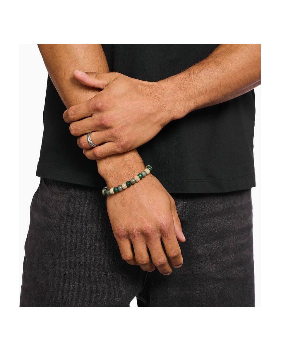 Bracelet stretch en beads ovales de jaspe, jade et labradorite porté par un homme avec une bague en argent.