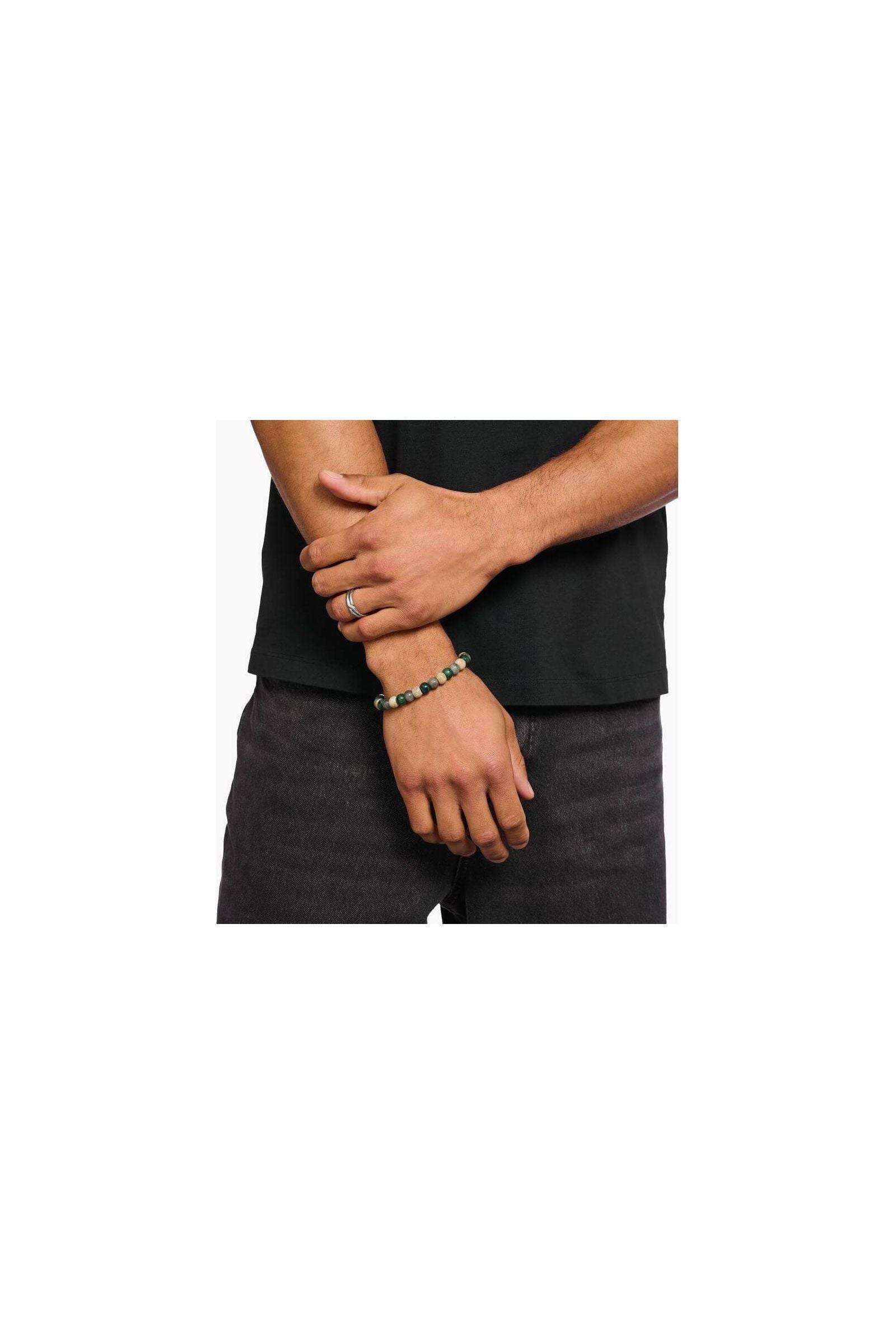 Bracelet stretch en beads ovales de jaspe, jade et labradorite porté par un homme avec une bague en argent.