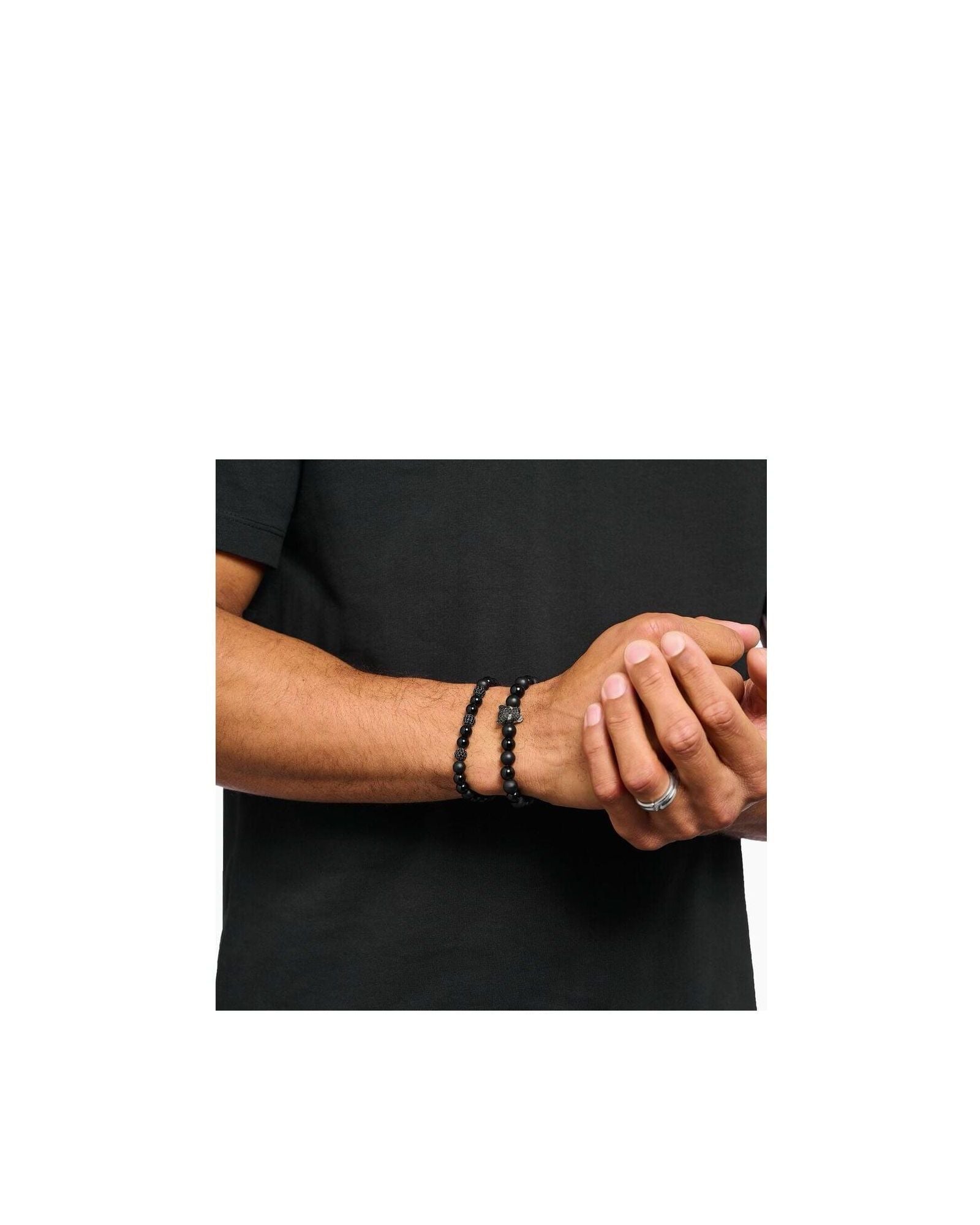 Homme portant un bracelet en obsidienne et zirconium noir, style rock-chic à la mode.