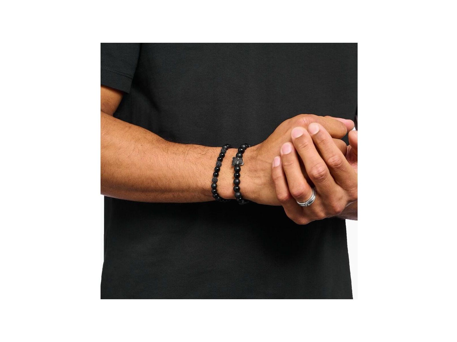 Homme portant un bracelet en obsidienne et zirconium noir, style rock-chic à la mode.
